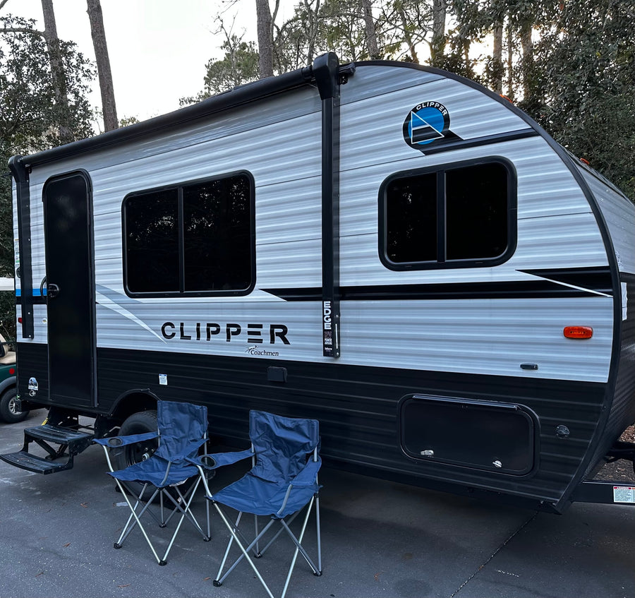 A grey and black Coachmen Clipper rv rental travel trailer is parked