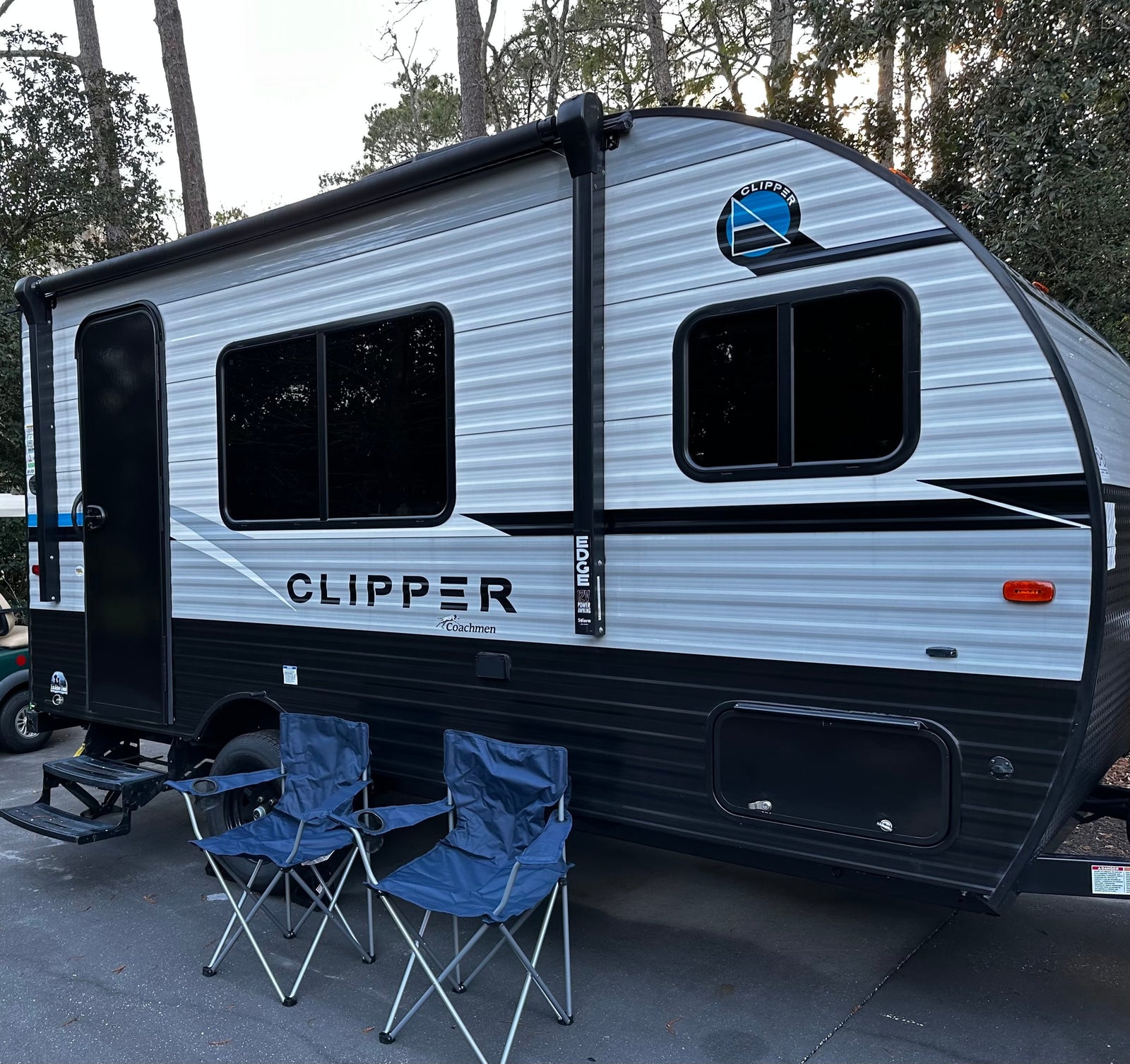 A grey and black Coachmen Clipper rv rental travel trailer is parked