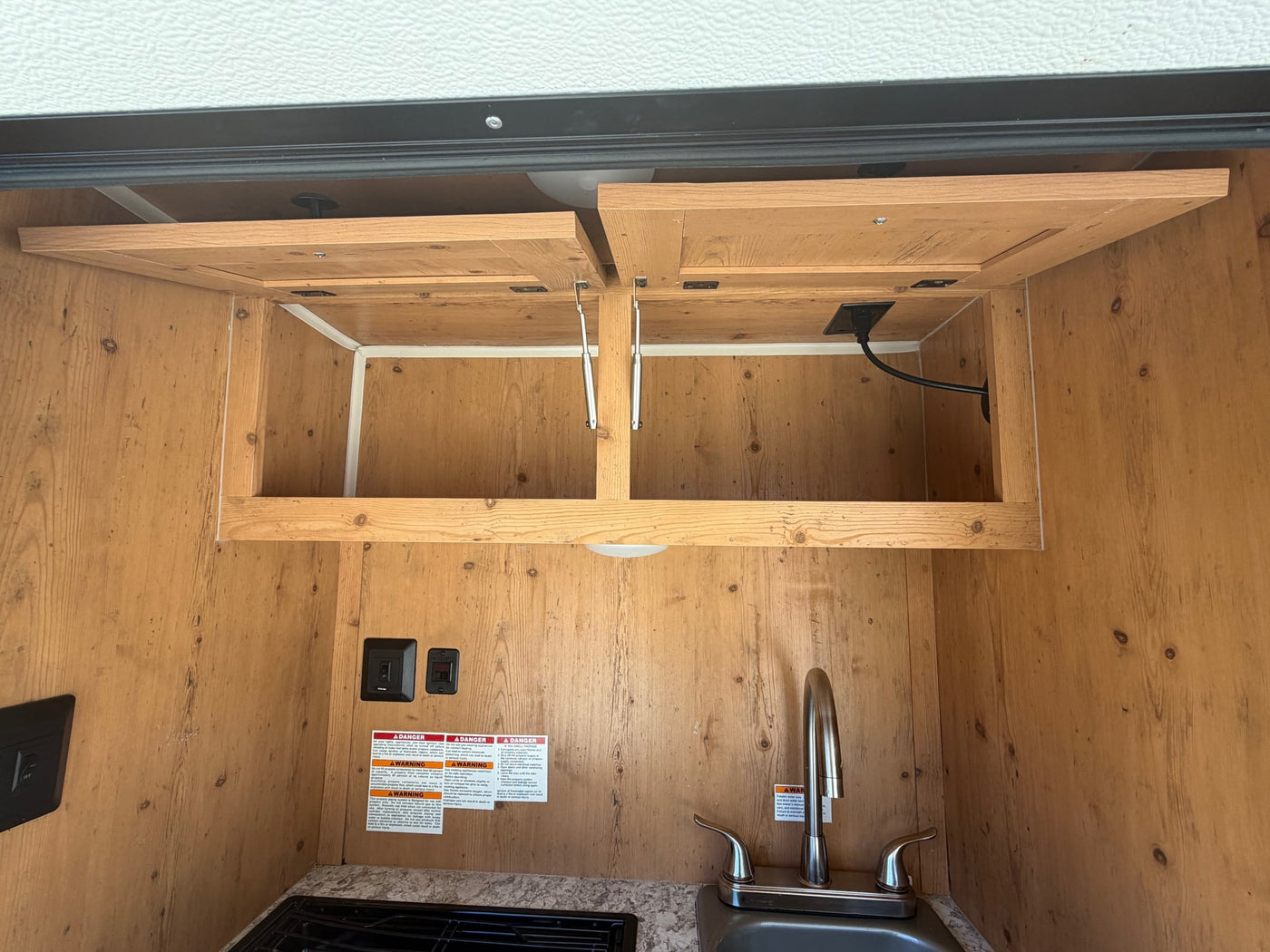 perfect for an RV rental adventure or rugged off-road camping.|Explore this RV rental's compact outdoor galley kitchen with wood cabinetry — photo 12