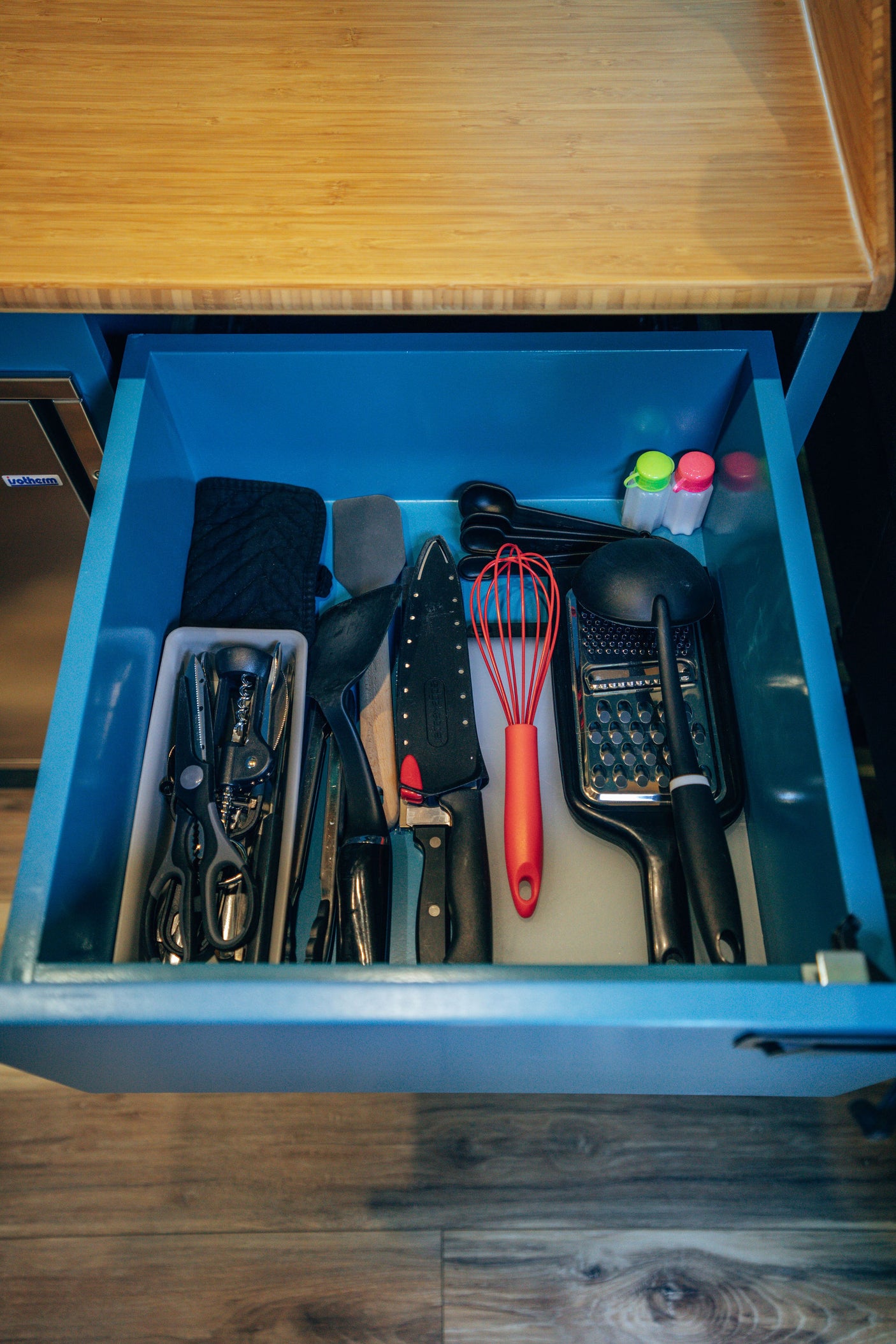 RV rental kitchen drawer: cooking utensils like whisk, grater, spatulas, and knives neatly organized for your adventures.