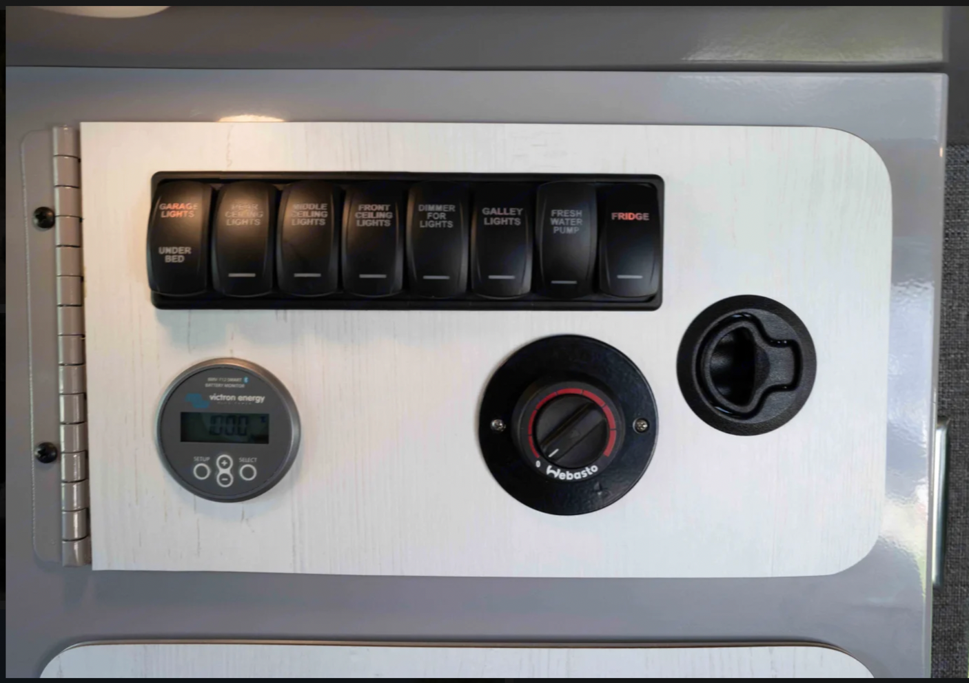 RV rental: Interior control panel for lights, water pump, fridge, Webasto heater, and Victron battery monitor.