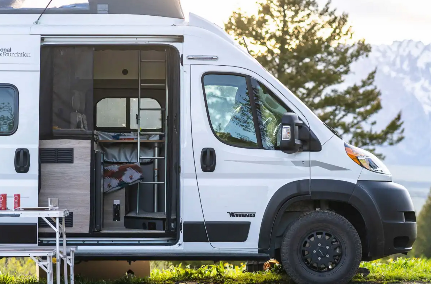 Adventure-ready white Winnebago RV rental parked outdoors, perfect for mountain camping and travel.