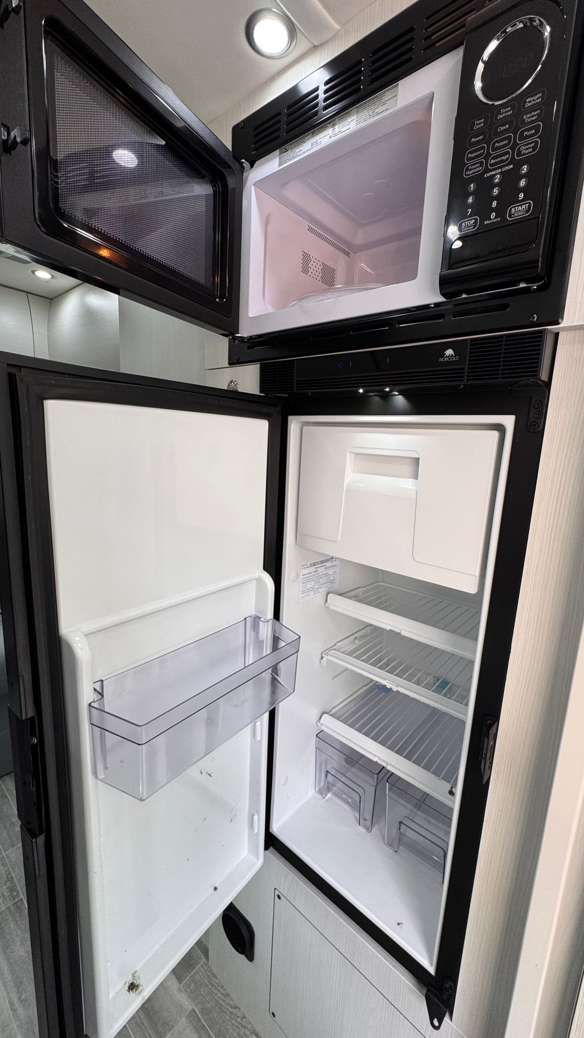 an excellent rv rental. Parked on asphalt next to modern houses.|Step inside this modern RV rental interior featuring a comfortable grey sofa — photo 10