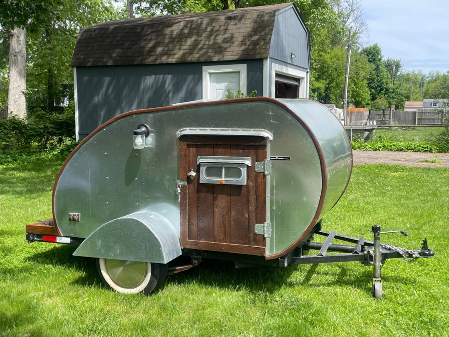 Silver teardrop camper on grass