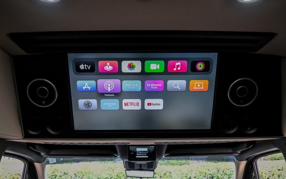 RV rental: An overhead Apple TV screen displays Netflix, YouTube, and other entertainment apps, offering premium in-vehicle media.