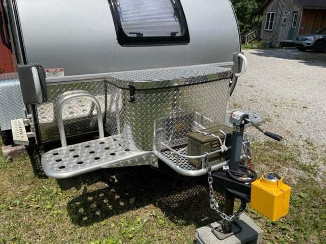Explore outdoors with this RV rental trailer, featuring diamond plate storage, front step, and hitch setup.