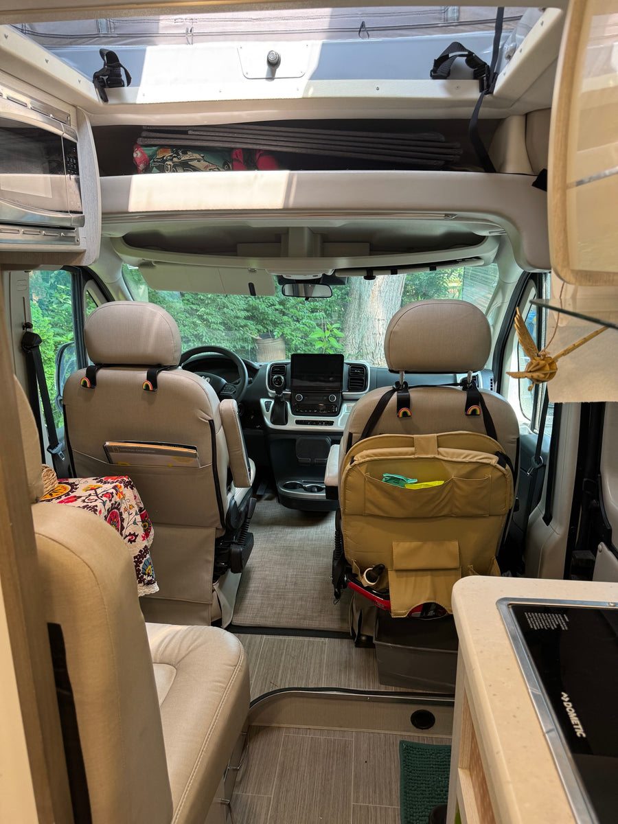Step into a modern rv rental. This camper van features swiveling front seats, a microwave, and kitchen amenities.