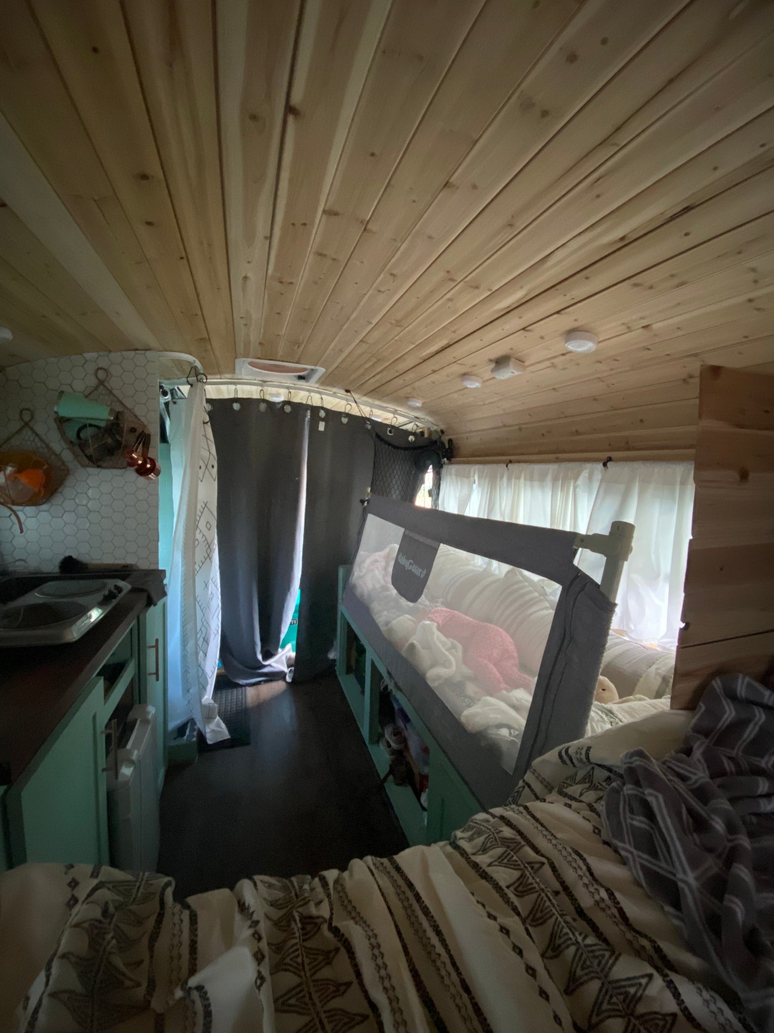 parked lakeside among pines. Ready for adventure!|Mint green skoolie RV rental