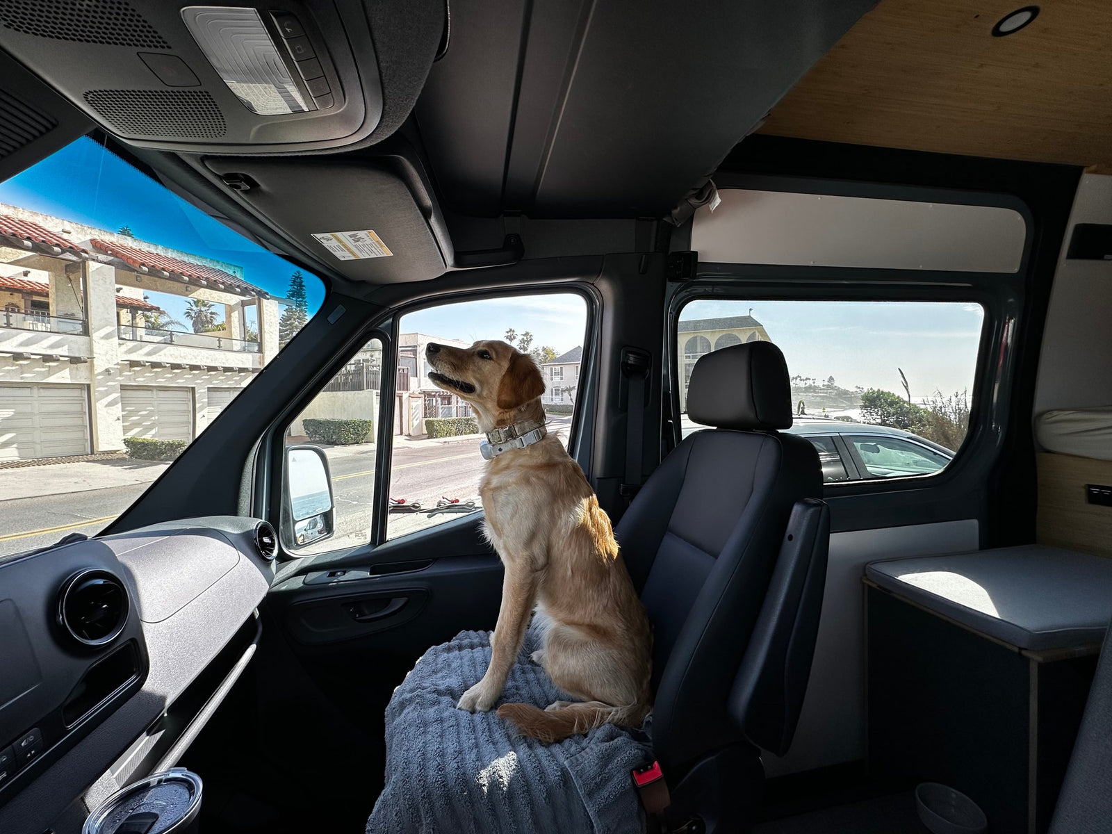 parked at a lighthouse on a sunny day.|Grey Mercedes Sprinter van