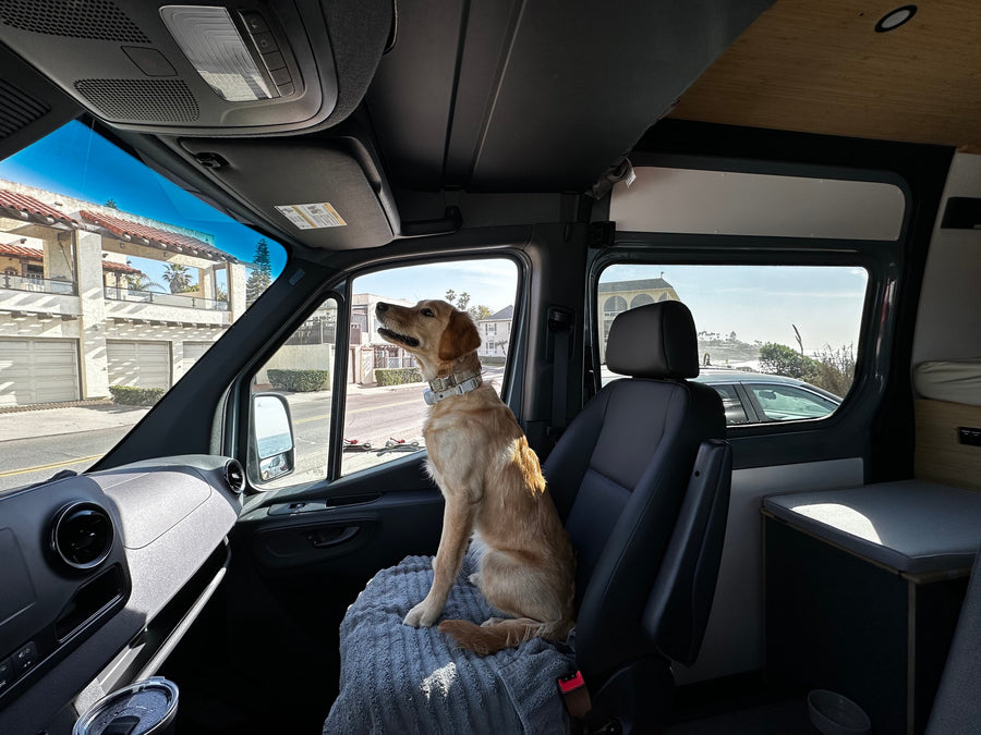 parked at a lighthouse on a sunny day.|Grey Mercedes Sprinter van