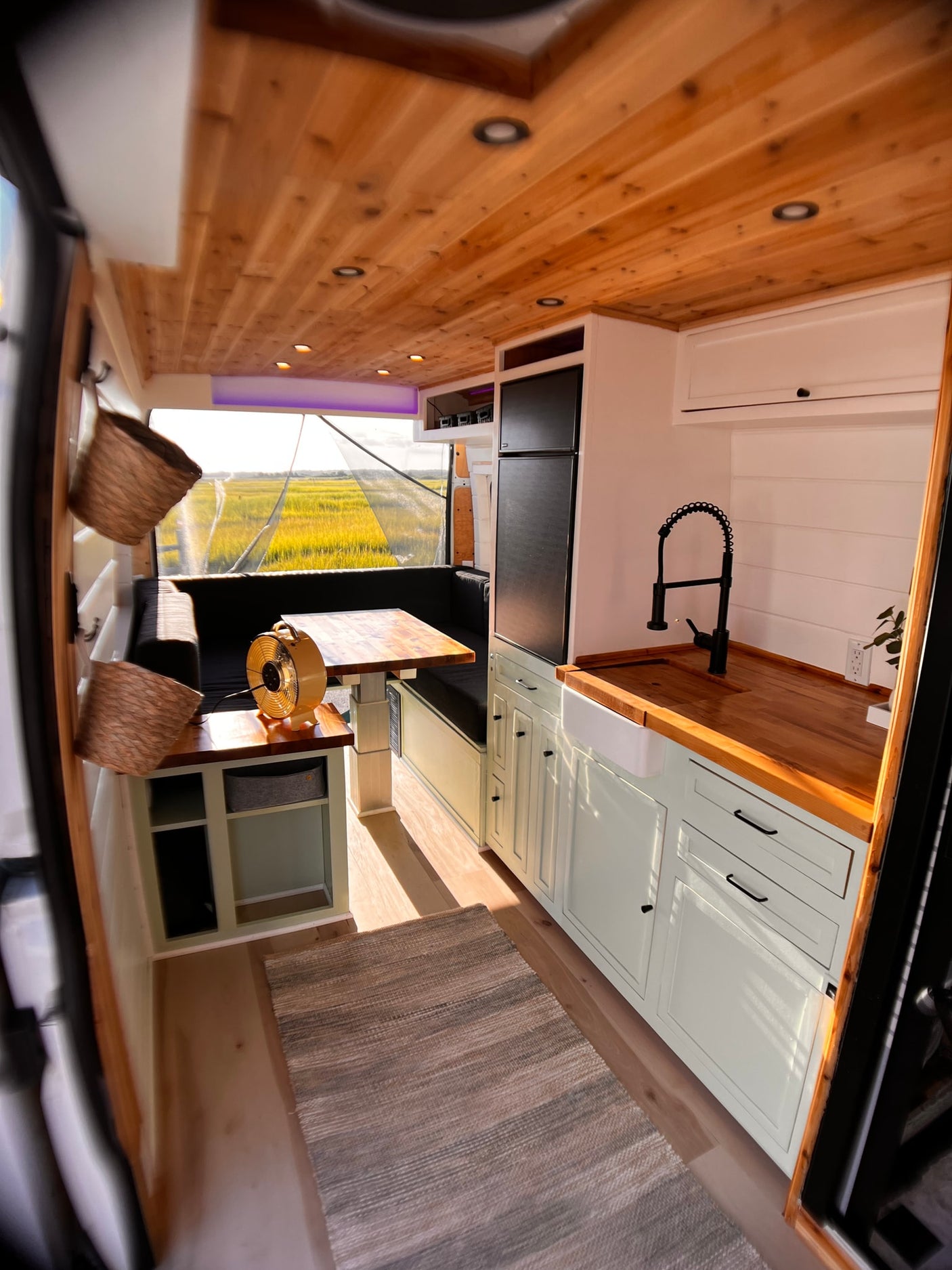 Spacious RV rental interior: modern kitchen, dining area, and cozy wood ceiling. Ideal for mobile living.