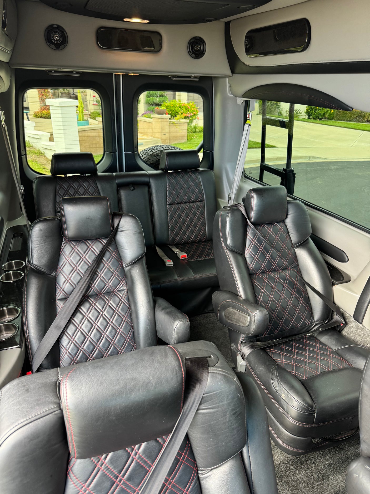 Luxurious rv rental interior: plush black leather seats with red diamond stitching, ample seating, and convenient amenities for travel.