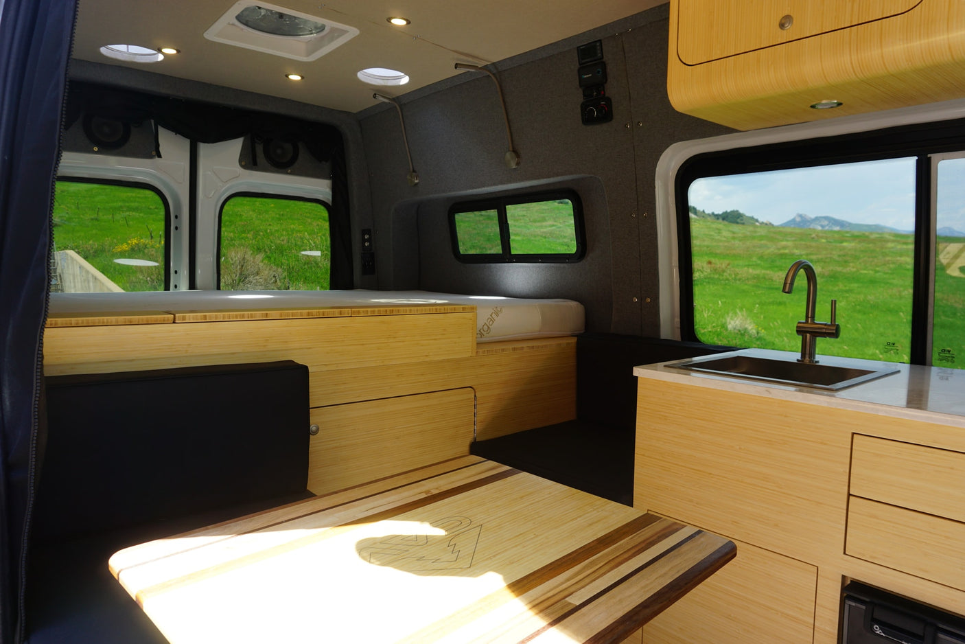 featuring mountain graphics and an awning for adventure trips.|Bright RV rental interior: Light wood cabinetry