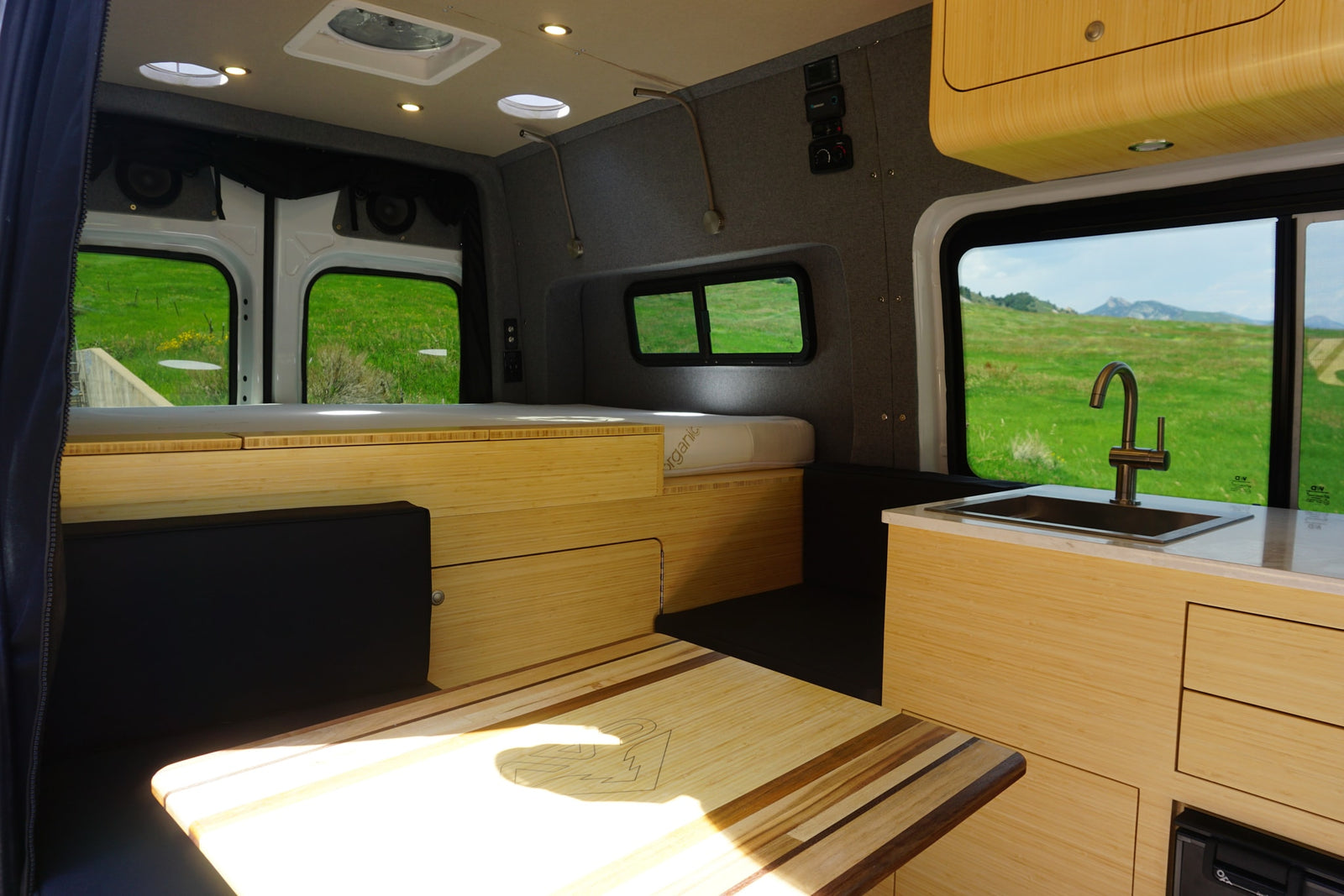 featuring mountain graphics and an awning for adventure trips.|Bright RV rental interior: Light wood cabinetry