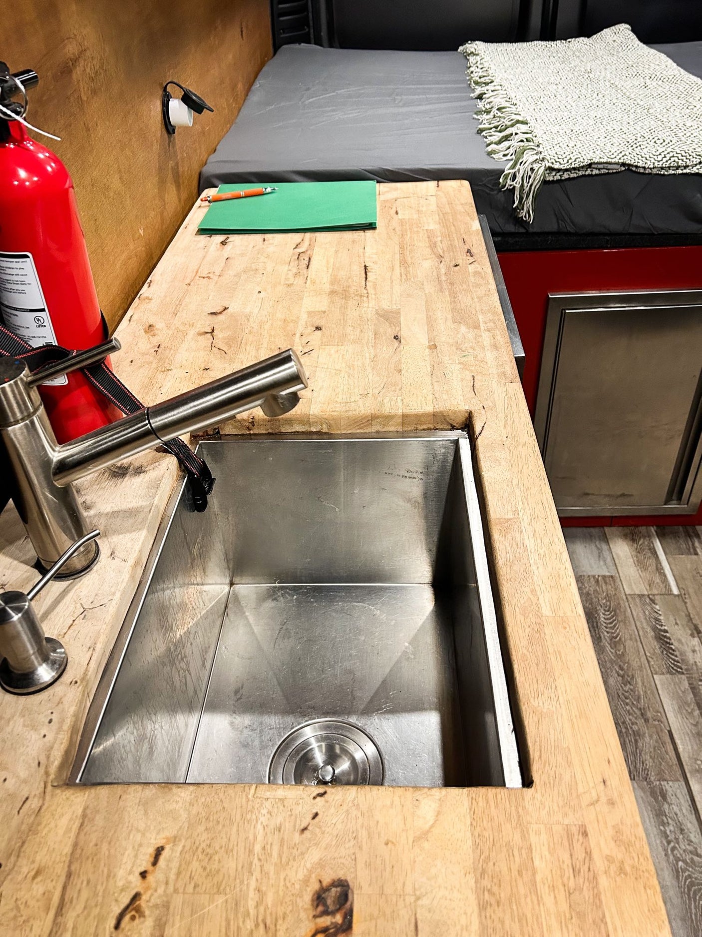 integrated for managing camper van systems.|Clever RV rental camper van interior. Features a compact red kitchen