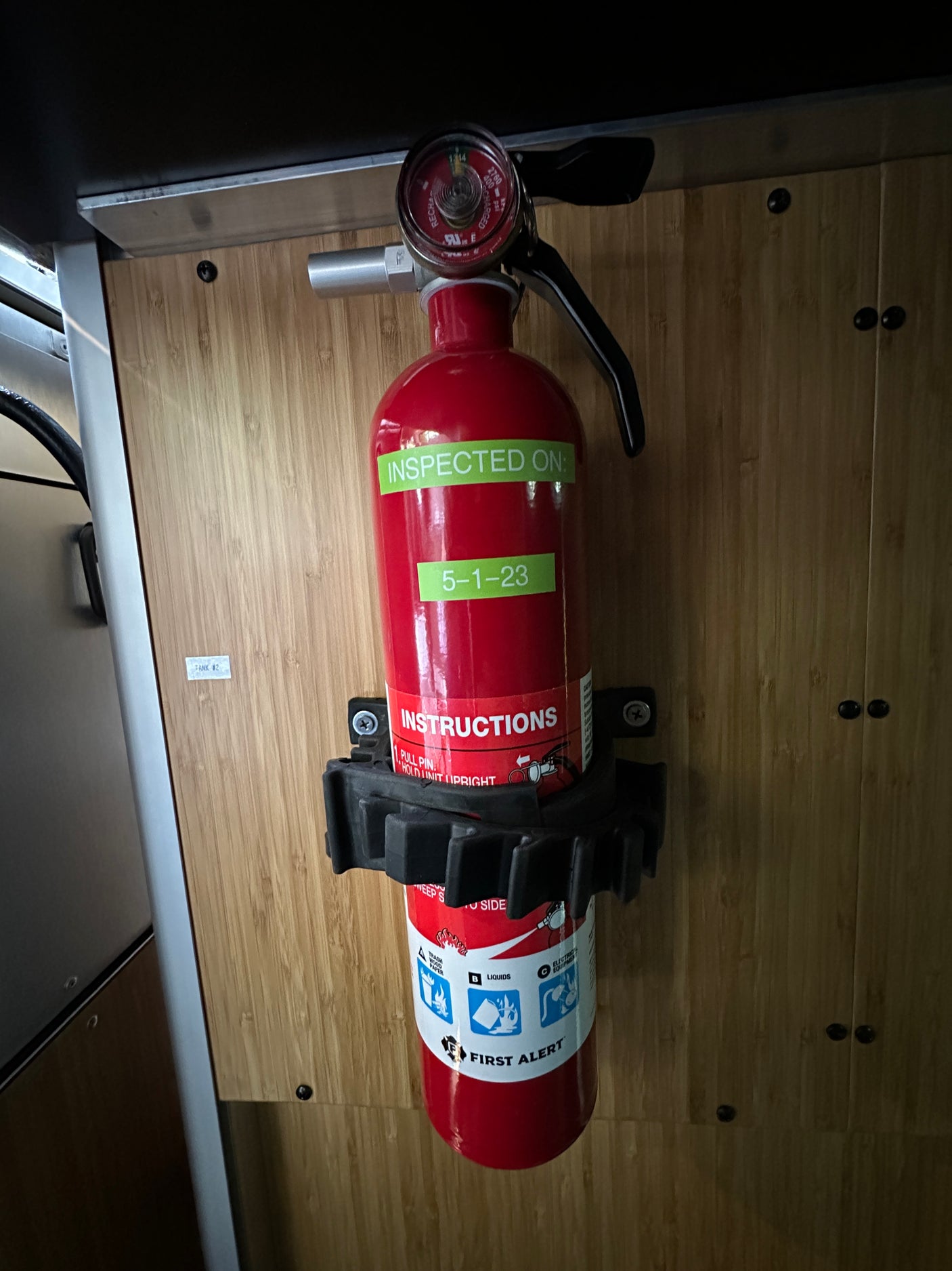 RV rental safety: A charged First Alert fire extinguisher, inspected 5-1-23, mounted and ready for emergencies.