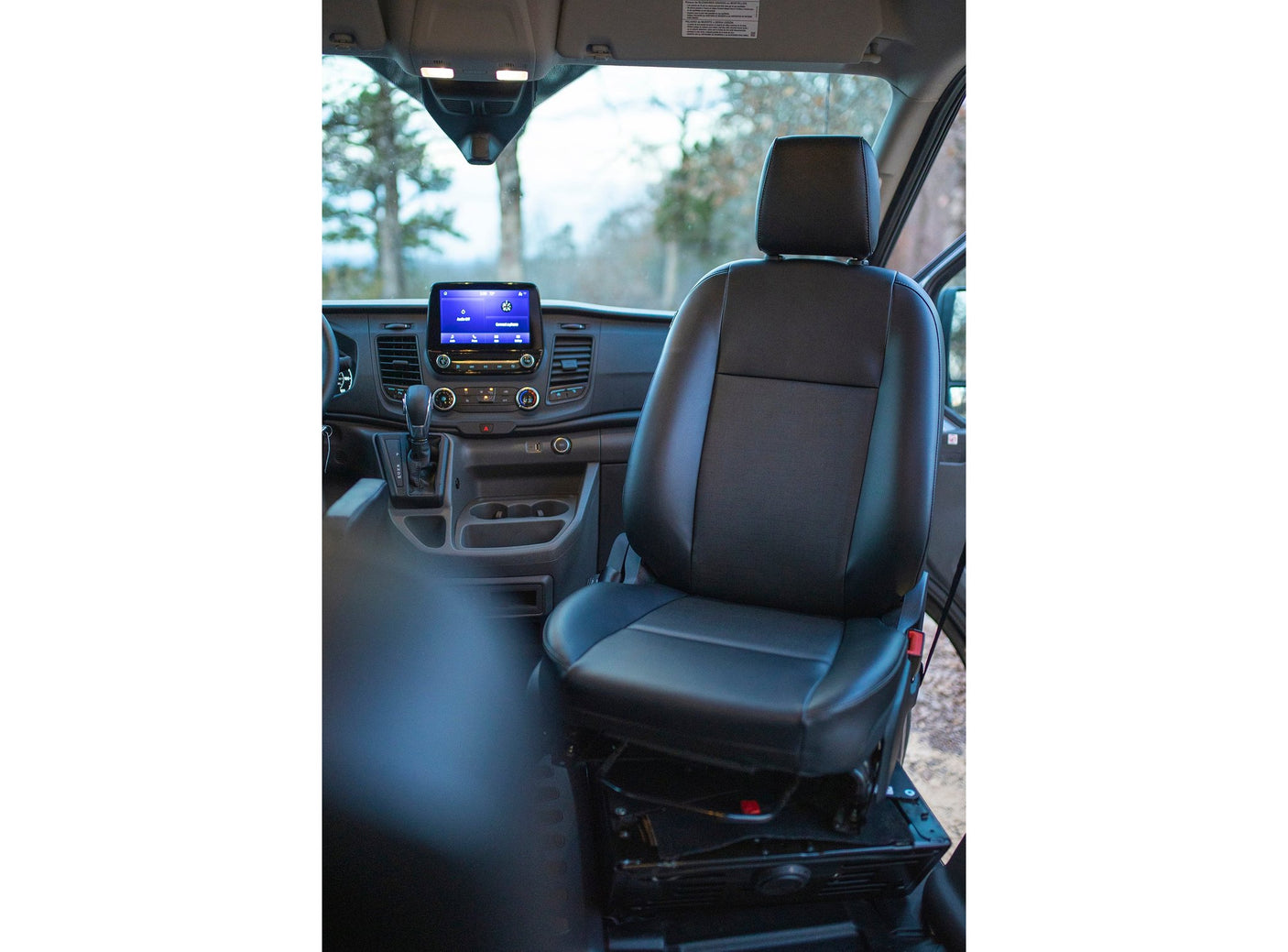 The clean interior of an RV rental, showing the black passenger seat, dashboard, and central infotainment screen clearly.