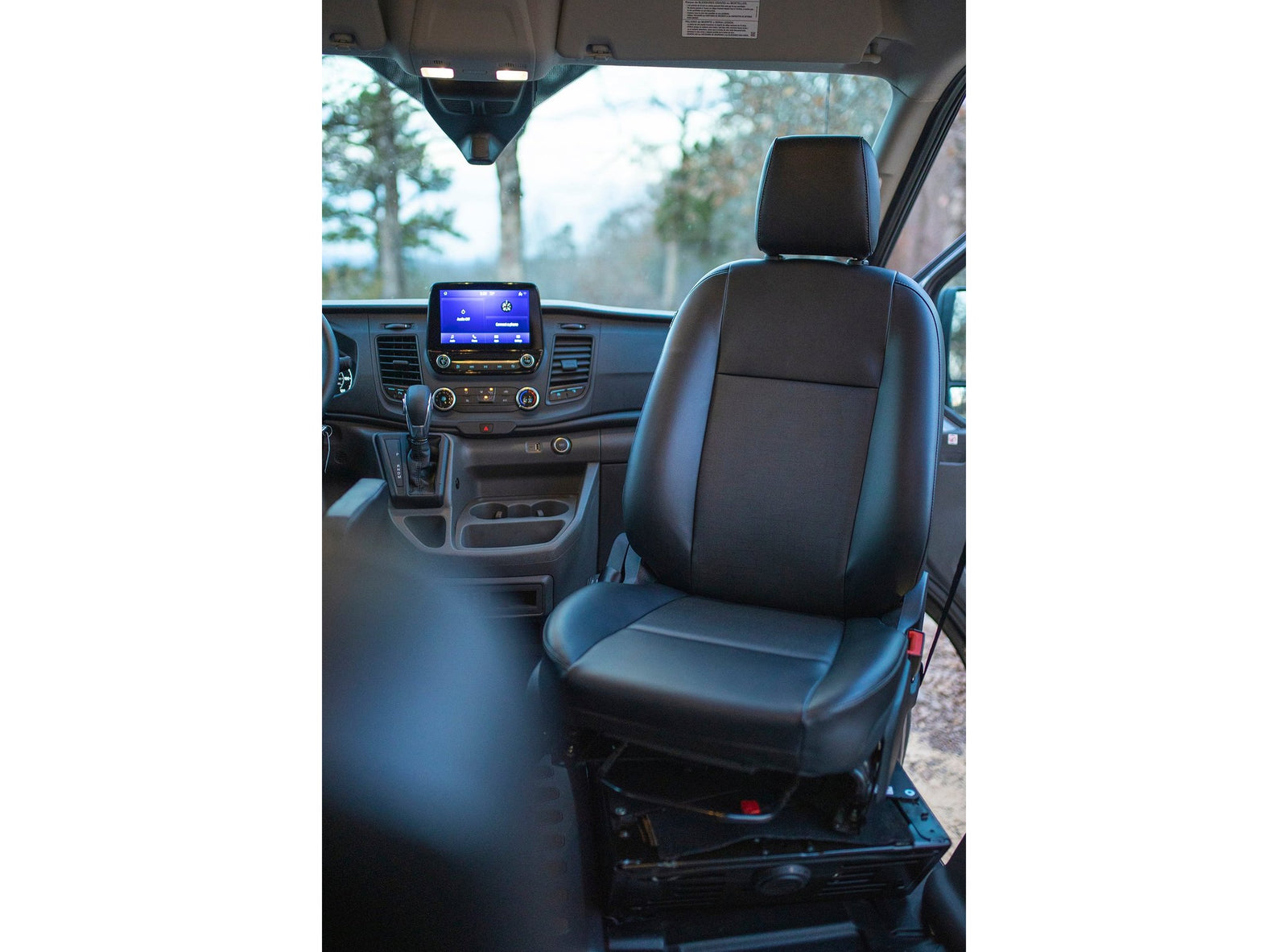 The clean interior of an RV rental, showing the black passenger seat, dashboard, and central infotainment screen clearly.