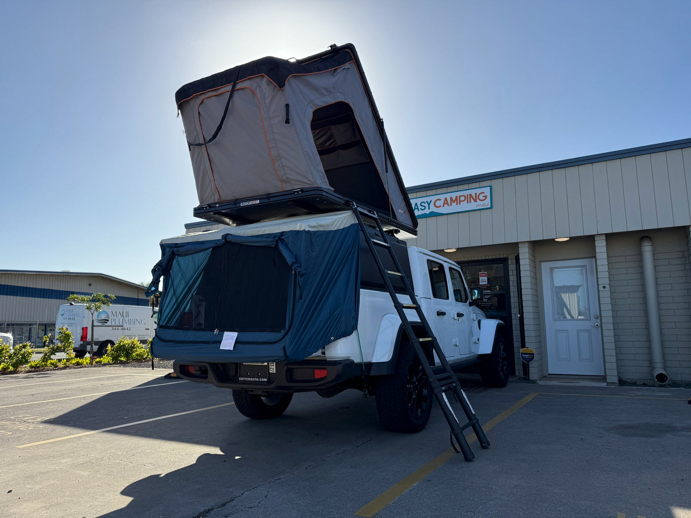 White Jeep Gladiator with a rooftop tent and annex set up for rv rental at Easy Camping Maui. Ready for adventure!