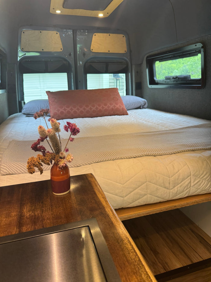 and side windows.|Cozy RV rental dining setup: a bottle of Highway 12 wine