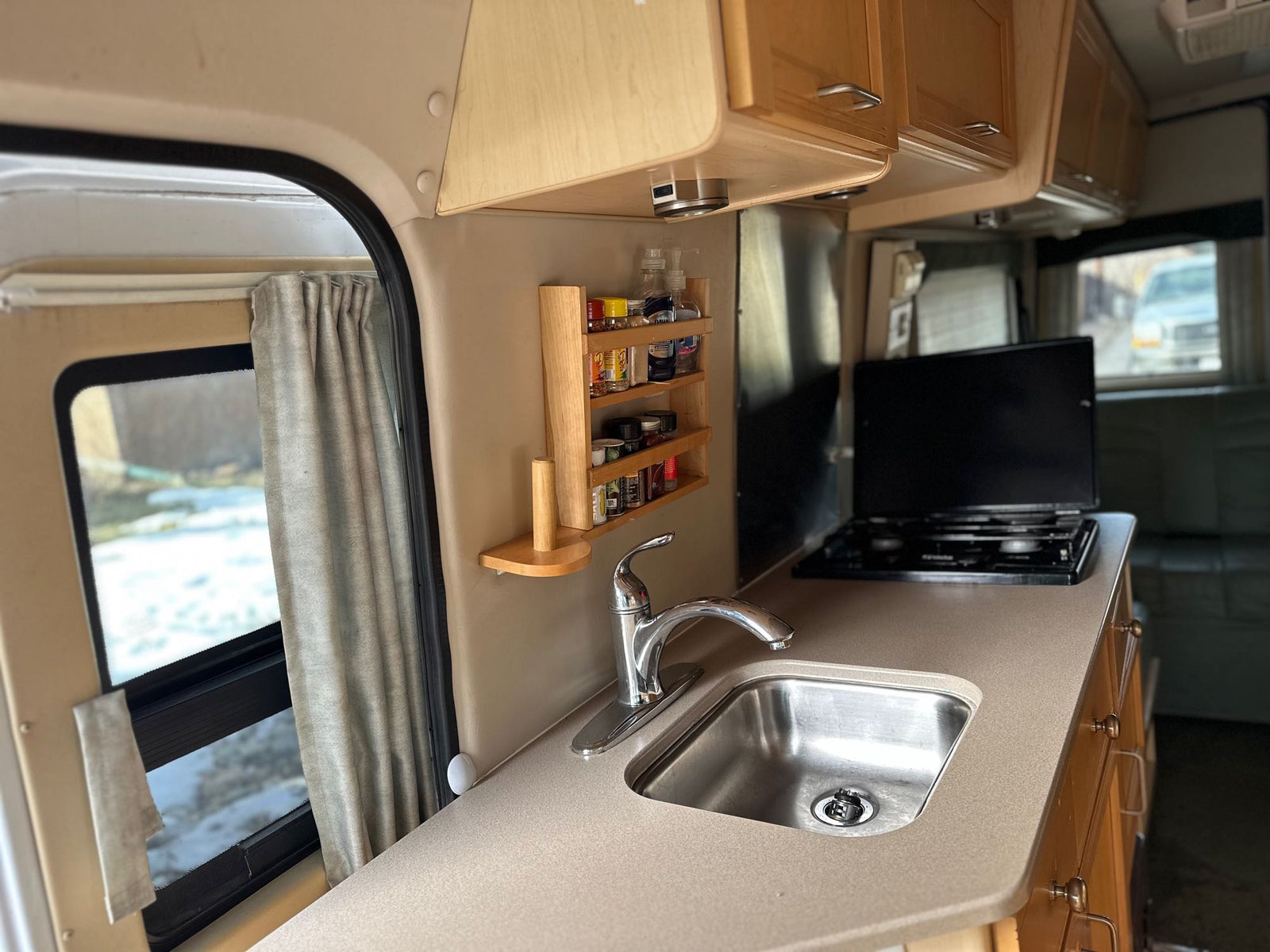 and an emergency exit.|RV rental interior featuring light green leather seating