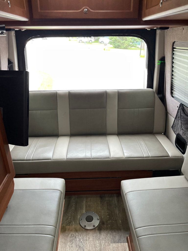 parked curbside. Dark tinted windows visible.|A white Mercedes-Benz Sprinter RV rental van with a sunshade