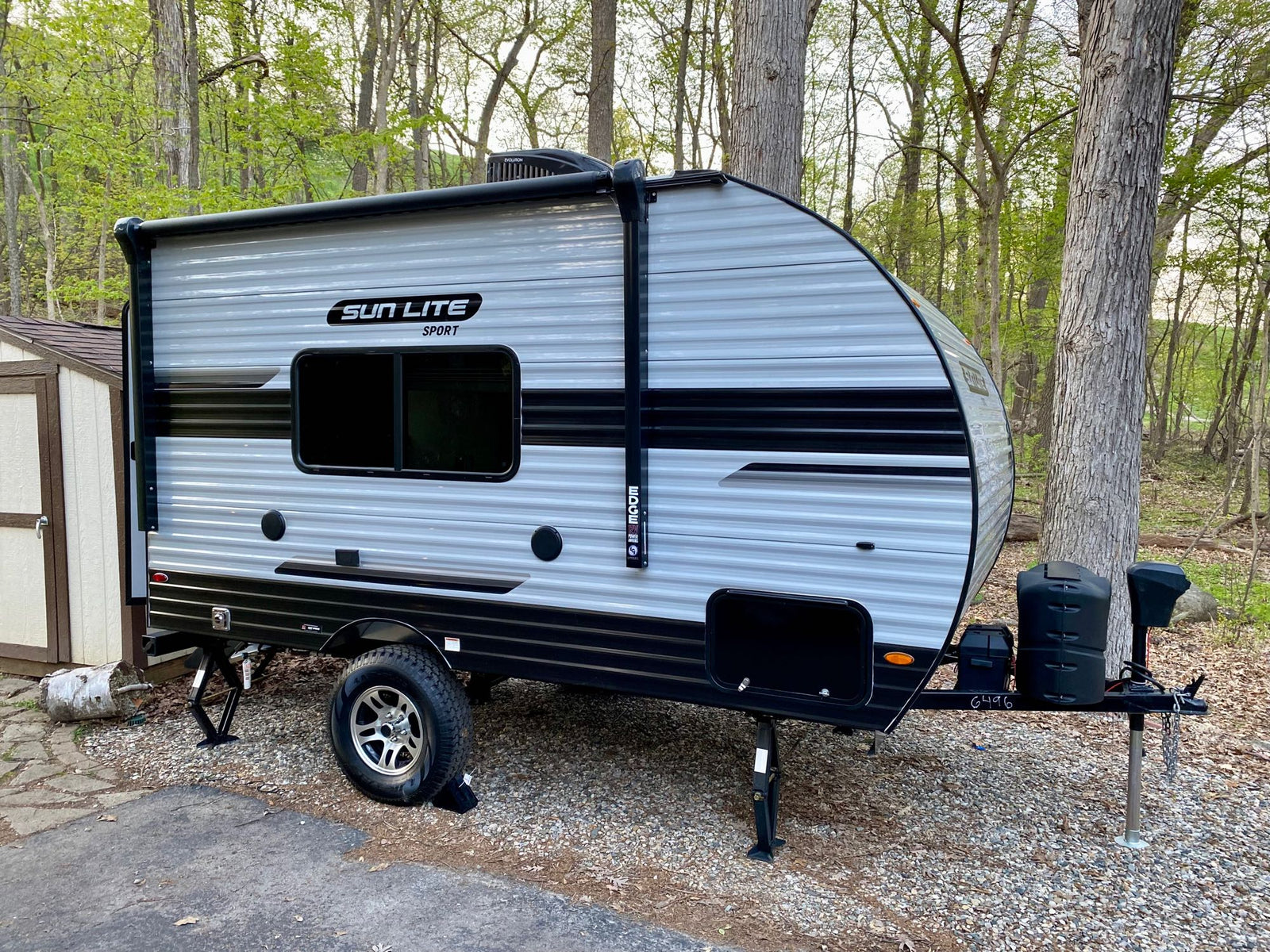 & sleeping areas for your travel trailer adventure.|RV rental campsite with a white Sun Lite trailer
