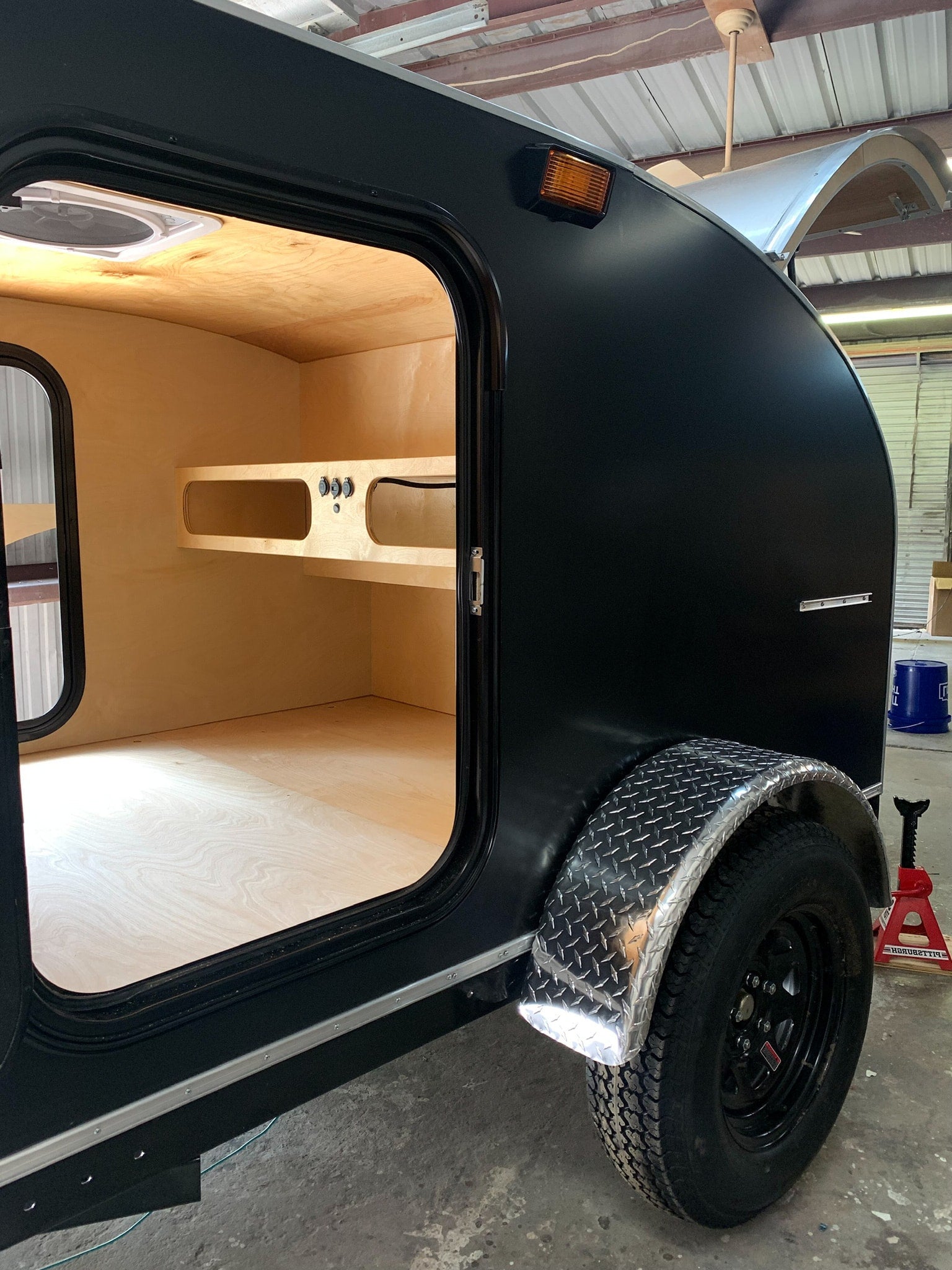 perfect for an RV rental adventure.|Black Wander Tears teardrop trailer **RV rental**. Open door reveals cozy interior