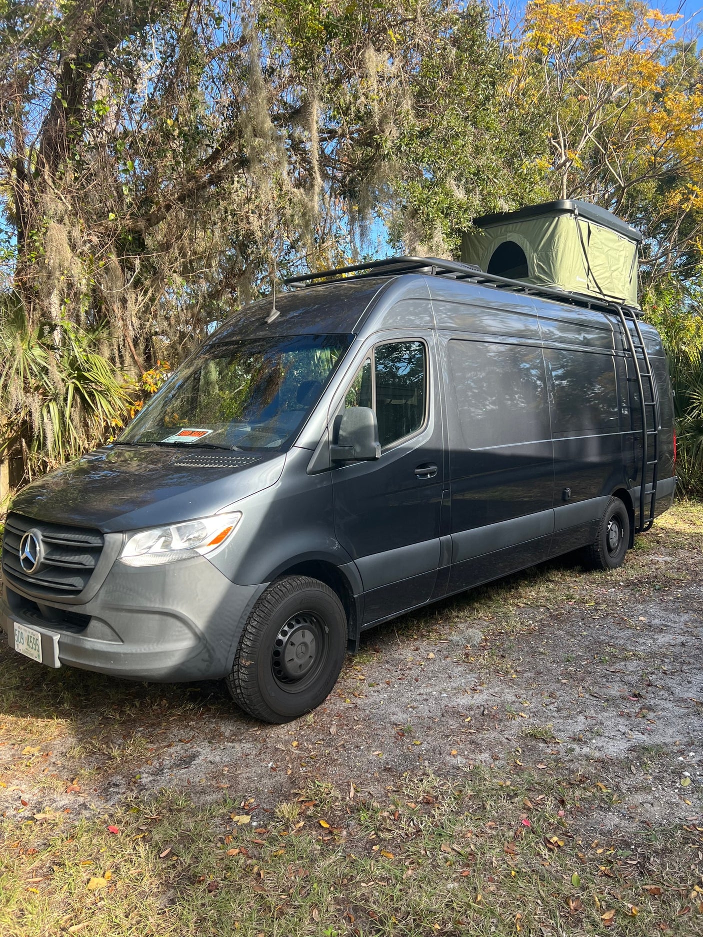 Dark gray Mercedes Sprinter camper van with rooftop tent. Ideal for RV rental adventures & camping trips.