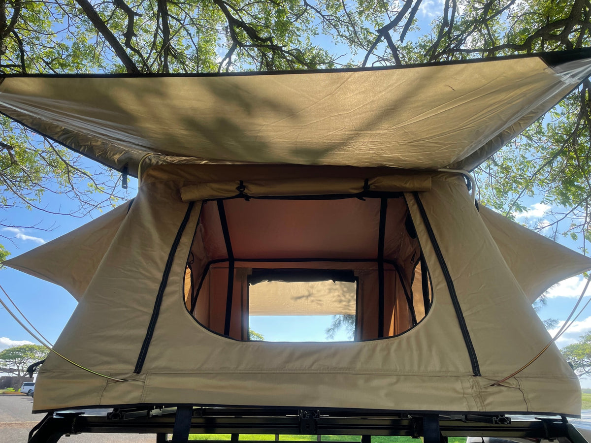Open beige rooftop tent, ready for your RV rental adventure. Enjoy camping with a view of trees and sky. — photo 7