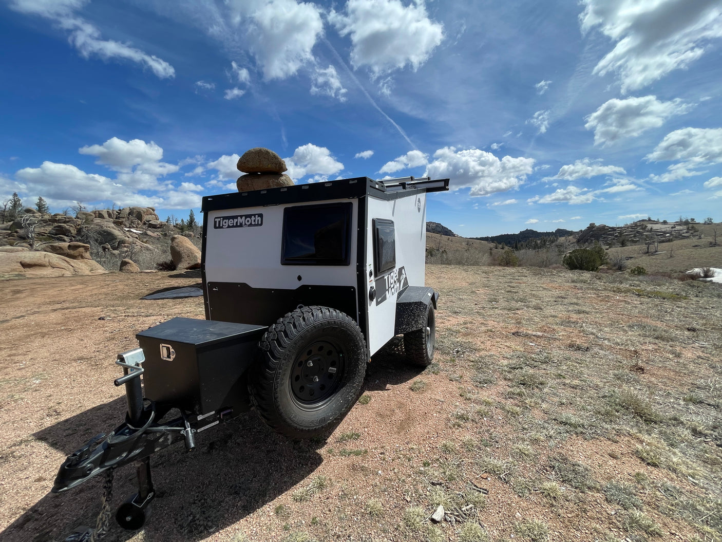 Ready for adventure: This white TigerMoth off-road RV rental camper is parked in a rugged, scenic landscape.