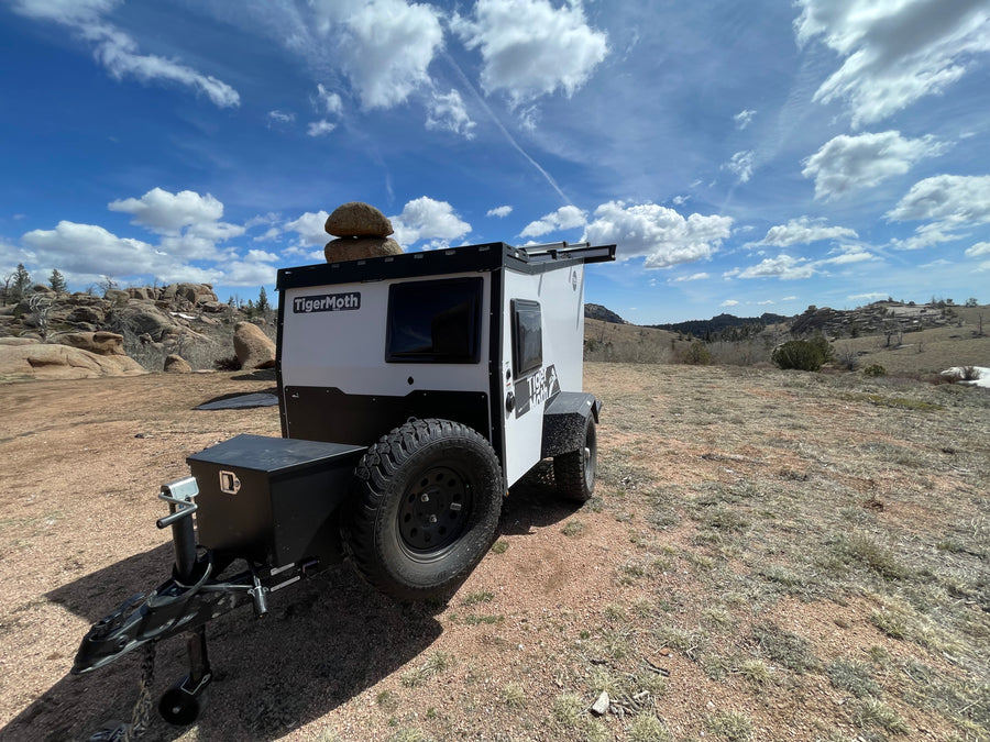 Ready for adventure: This white TigerMoth off-road RV rental camper is parked in a rugged, scenic landscape.