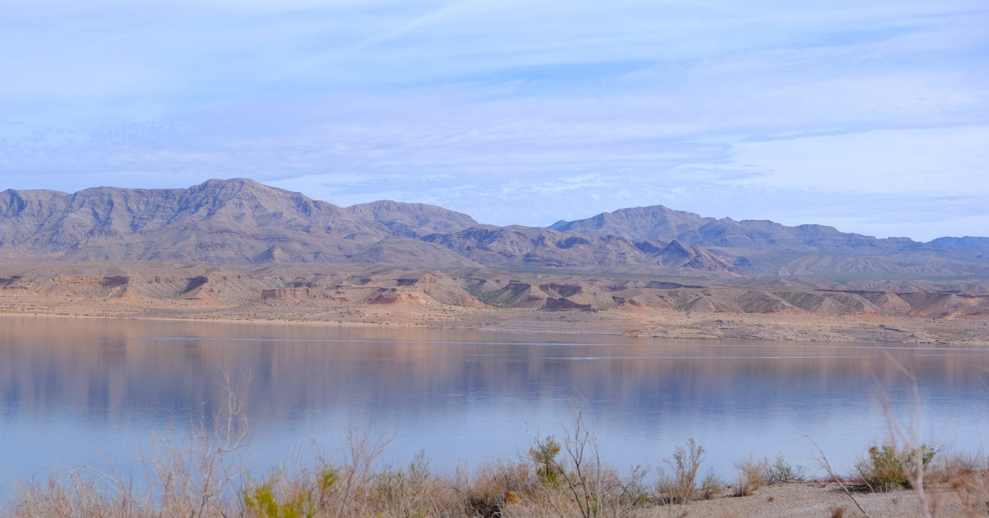 Majestic mountains meet a calm lake in this desert panorama. Discover hidden gems with an RV rental.