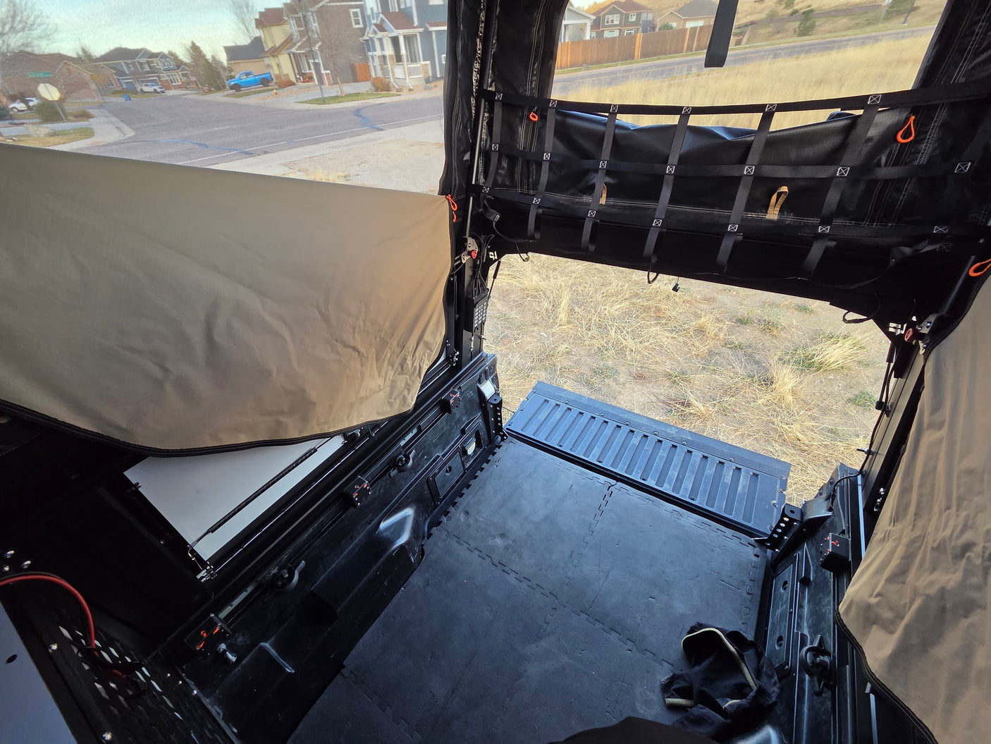 Spacious truck bed camper interior, ready for adventure. Perfect for an RV rental getaway with views of residential streets.