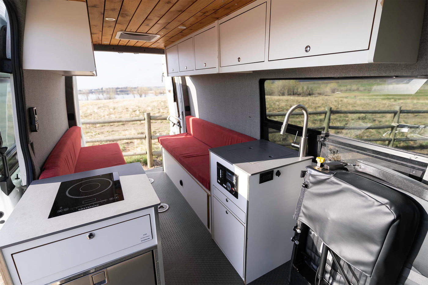 Spacious RV rental interior featuring a kitchenette with cooktop and sink — photo 1