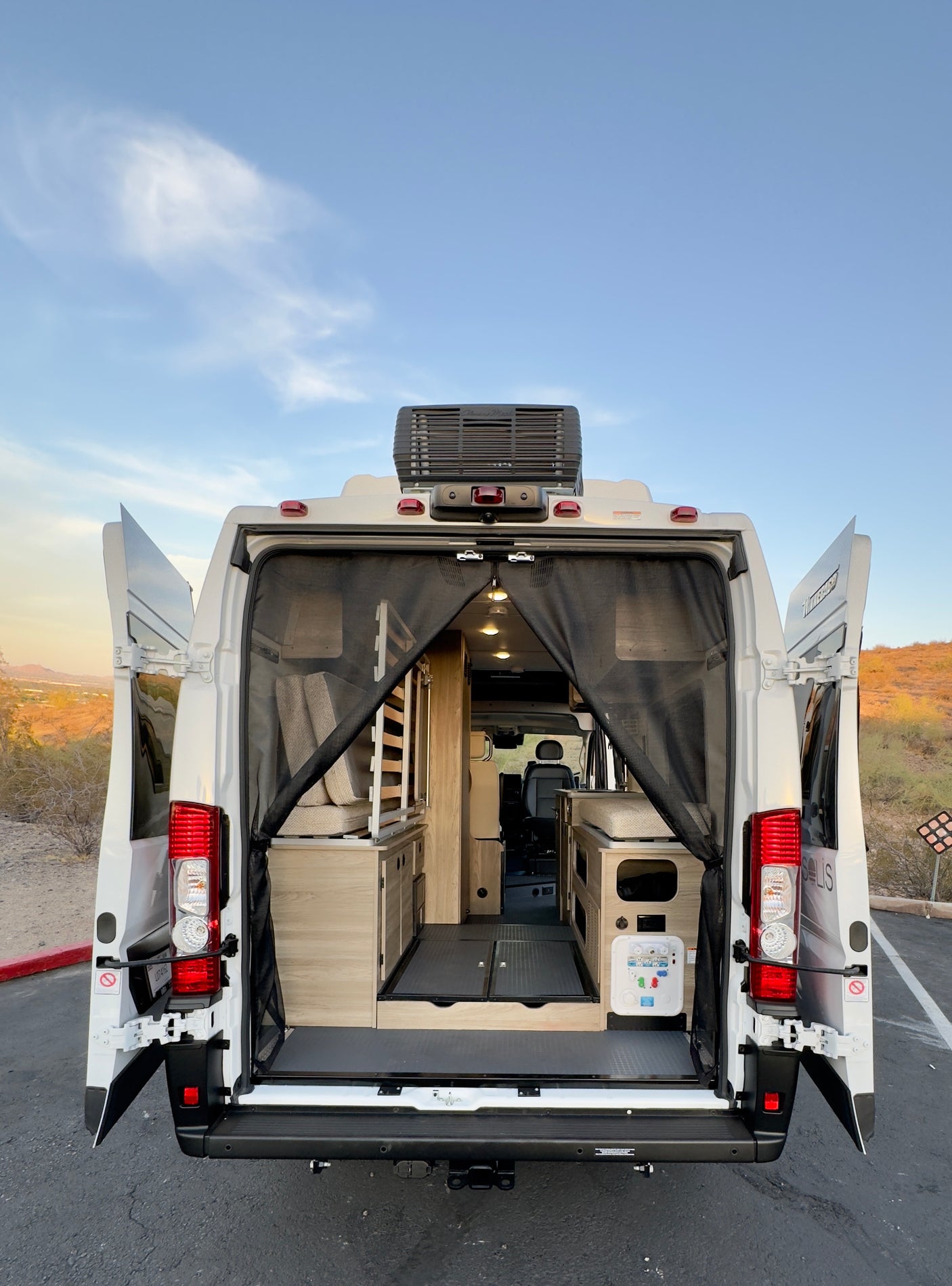 Experience freedom! This RV rental van's open rear reveals a spacious, customized interior for your next road trip adventure.