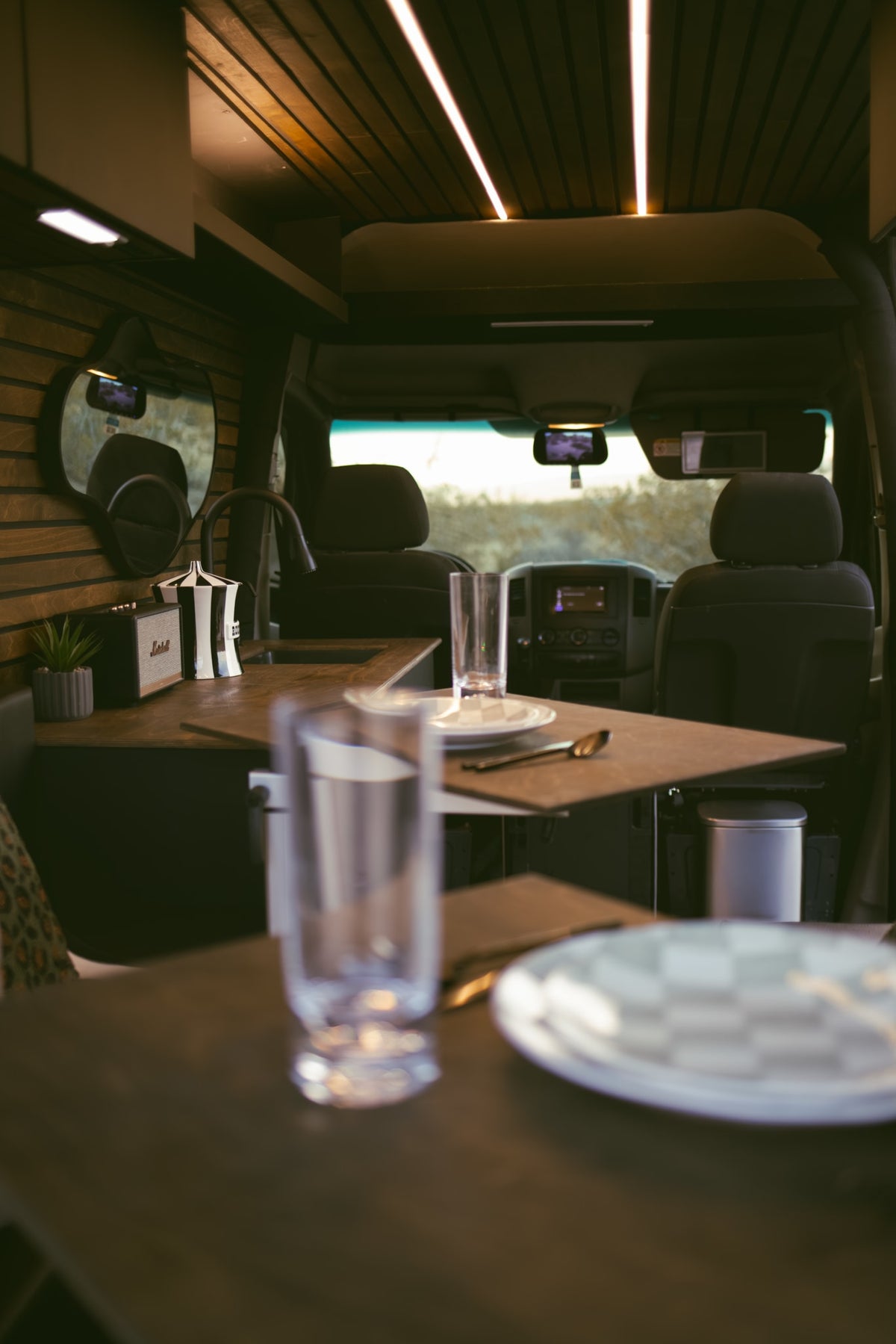 and plush seating.|Cozy rv rental camper van interior with a comfortable bed and pillows — photo 9