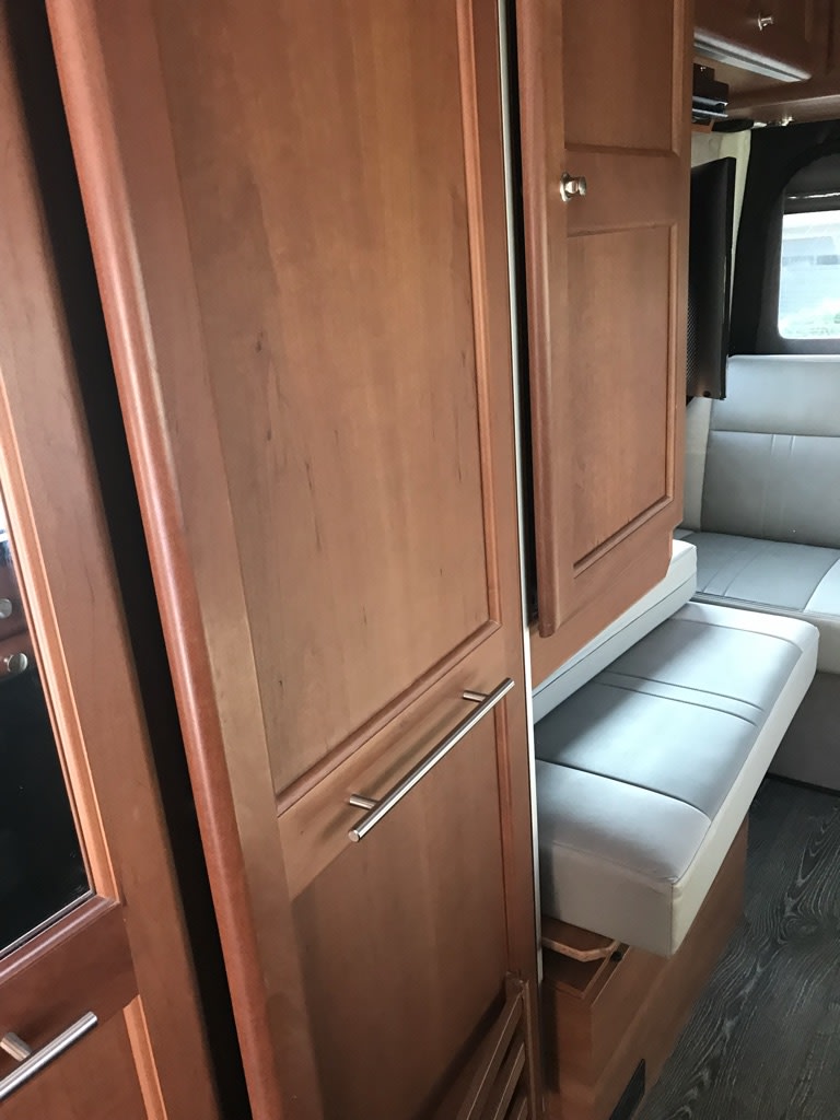 with tinted windows and a California plate.|Step inside this RV rental: a cozy interior featuring a bed area