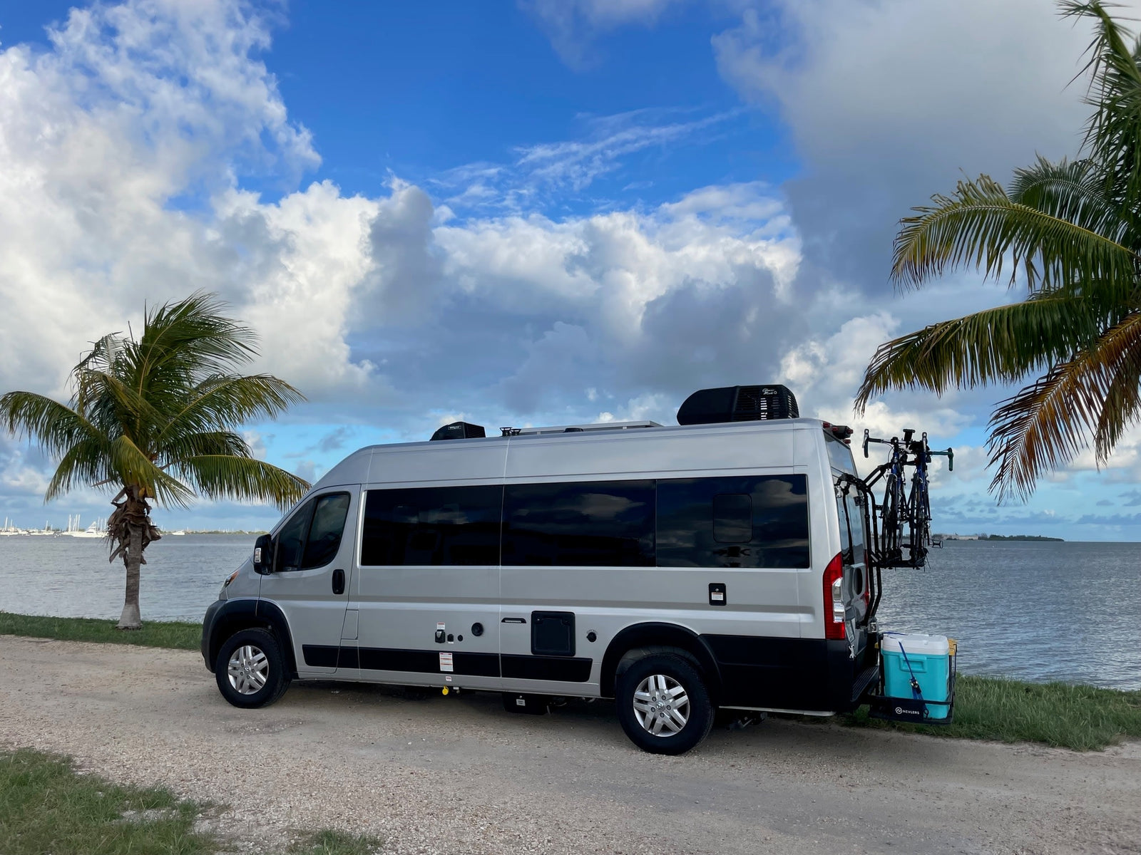 Silver RV rental by tropical water with bikes