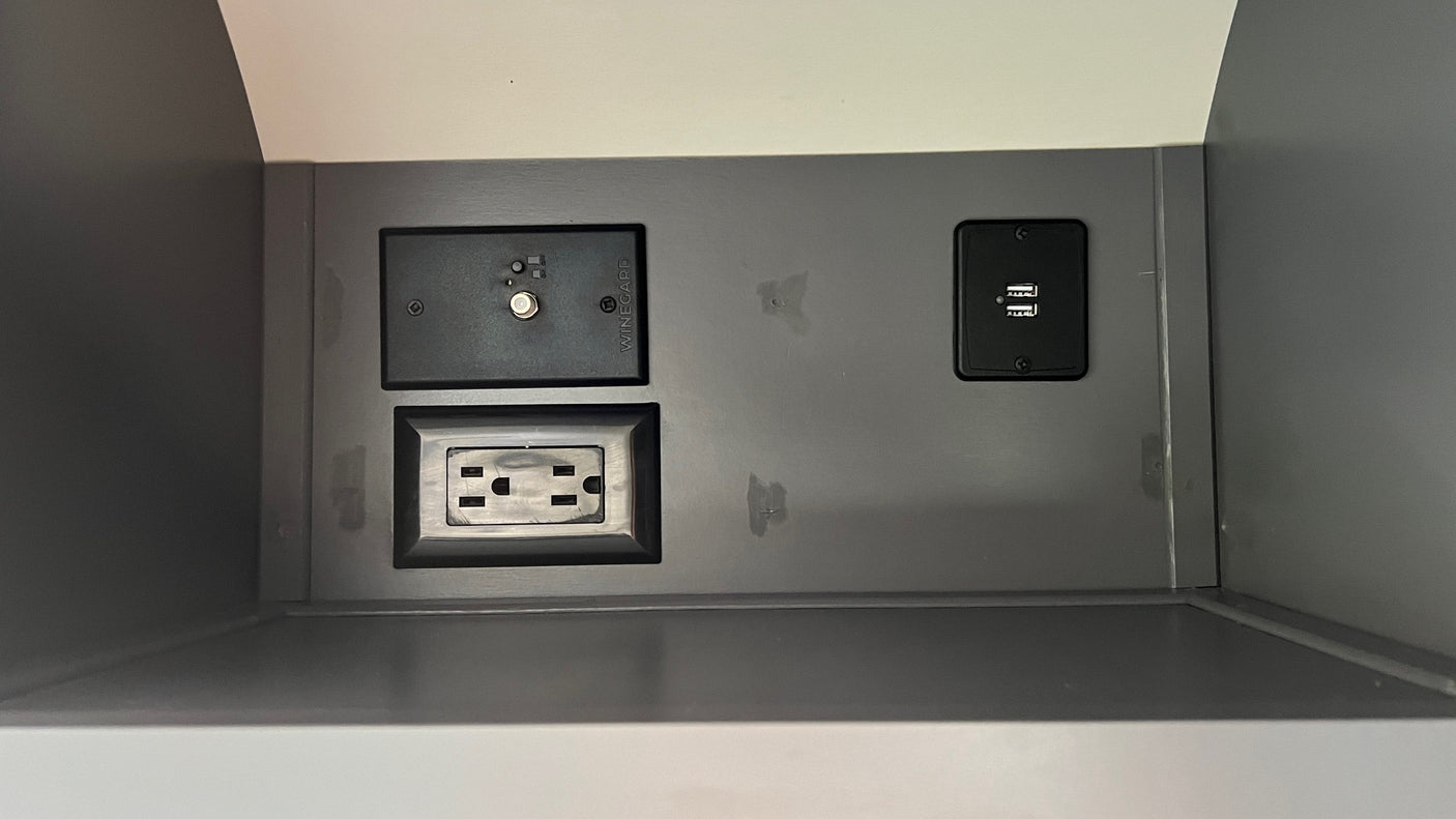 Inside an RV rental: a power panel with a coaxial hookup, standard AC outlet, and dual USB charging ports.