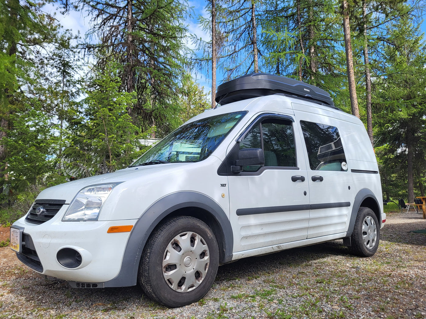 with two pillows & warm lights.|Inside an RV rental van: a cozy bed setup with wooden slats — photo 13