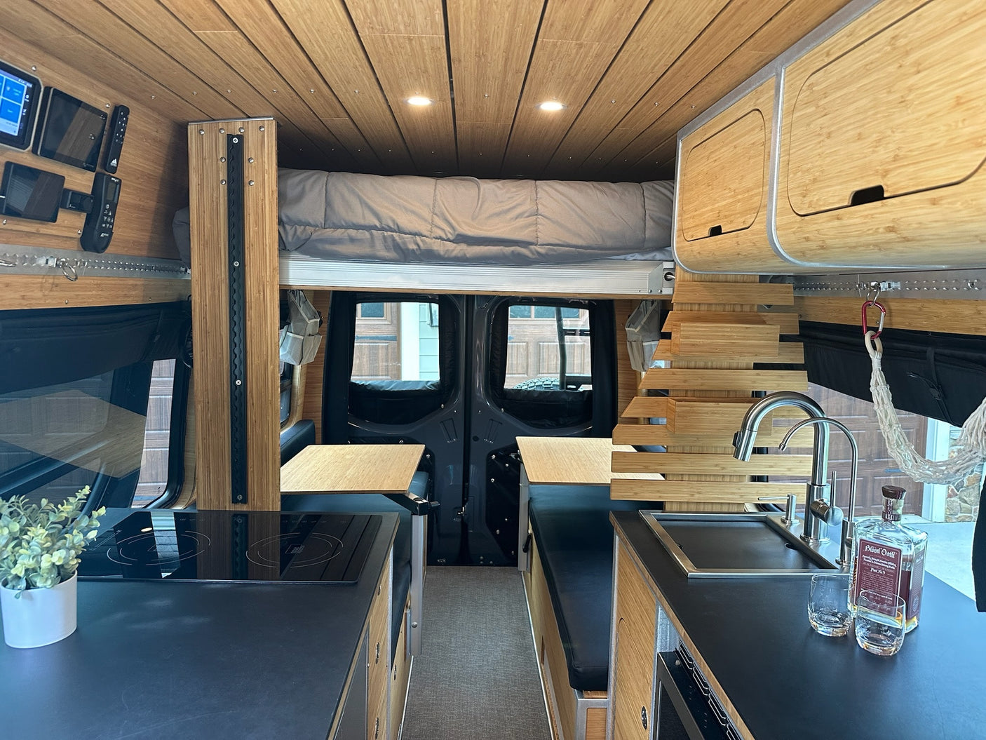 awaits your adventure on a wet road by a lake and trees.|Luxurious RV rental interior: bamboo walls