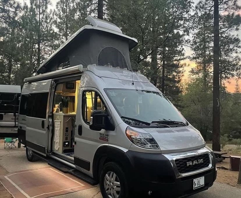 Ready for adventure: a light gray RV rental with an open pop-top & bright interior