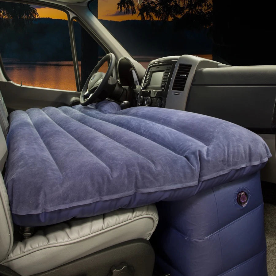 RV rental front seat air mattress for car camping: comfy sleeping setup in a van, with a twilight lake view outside.