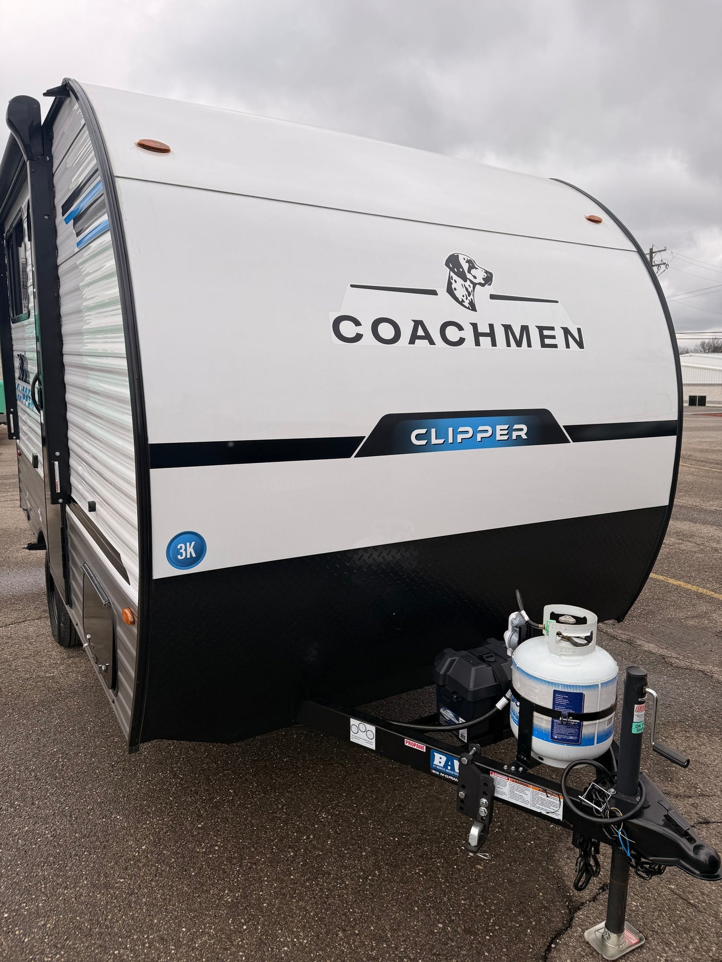 Front of a white Coachmen Clipper travel trailer, equipped with a propane tank, ready for an rv rental camping adventure.