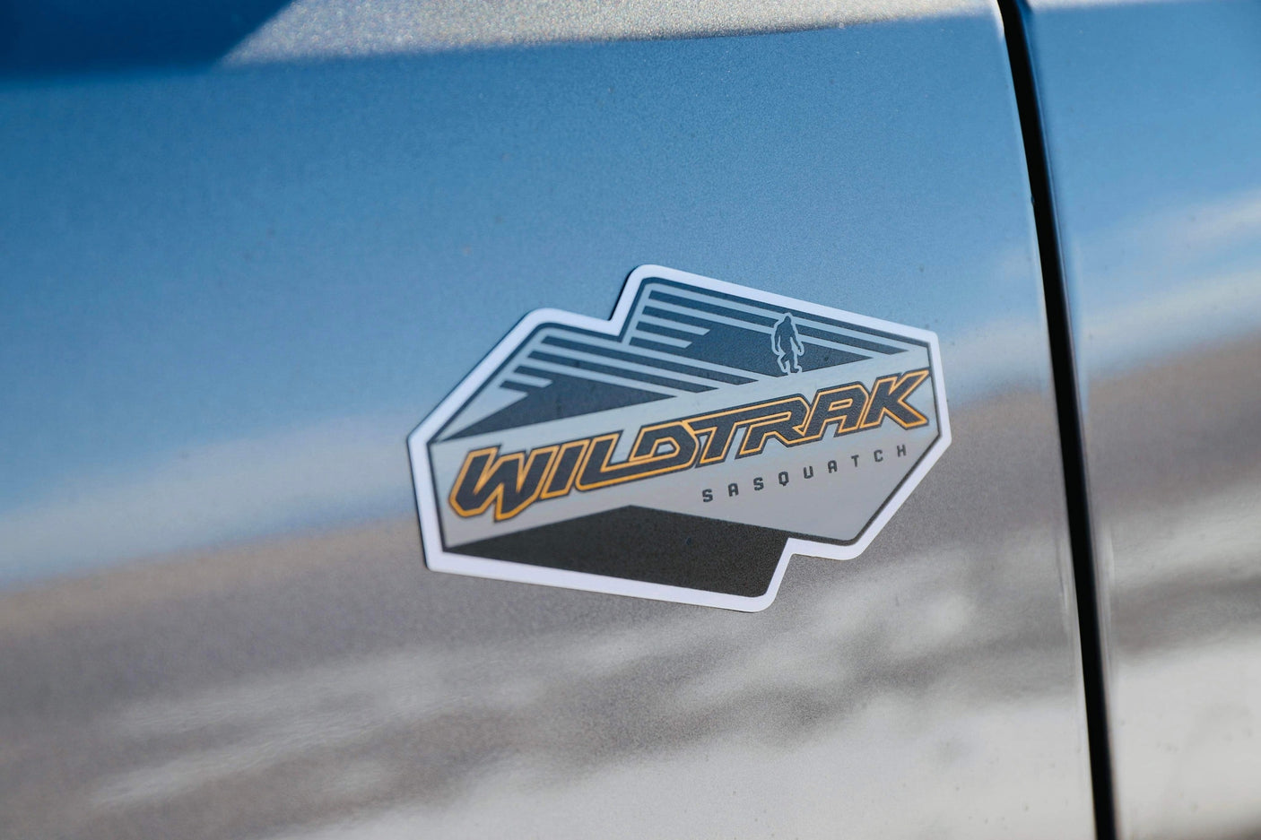 WILDTRAK SASQUATCH emblem (orange text, bigfoot silhouette) on a blue adventure vehicle. Ready for your RV rental journey!