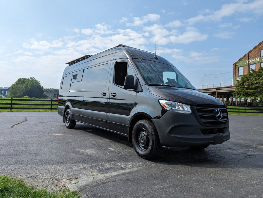 Sleek black Mercedes Sprinter camper van RV rental parked outdoors