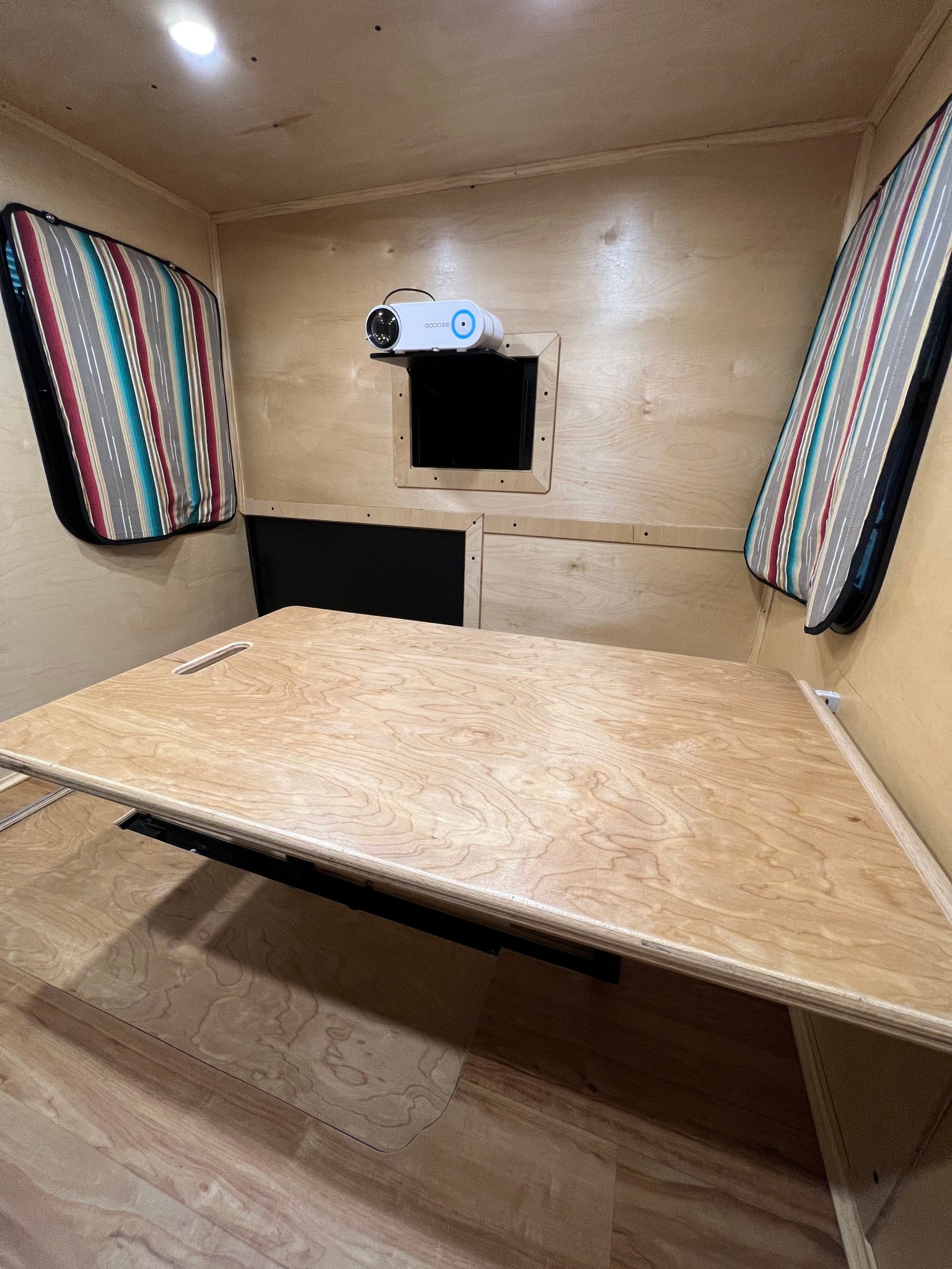 with two chairs & a table set up.|A woman smiles while cooking outdoors at the pull-out kitchen of her RV rental