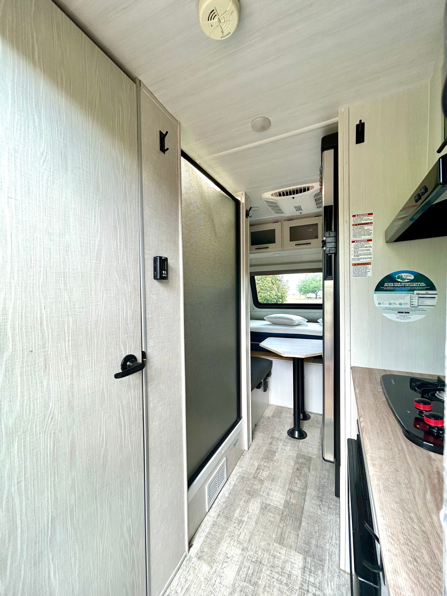 RV rental interior showing a light-colored door, shower, and compact kitchen/dinette area, designed for travel convenience.