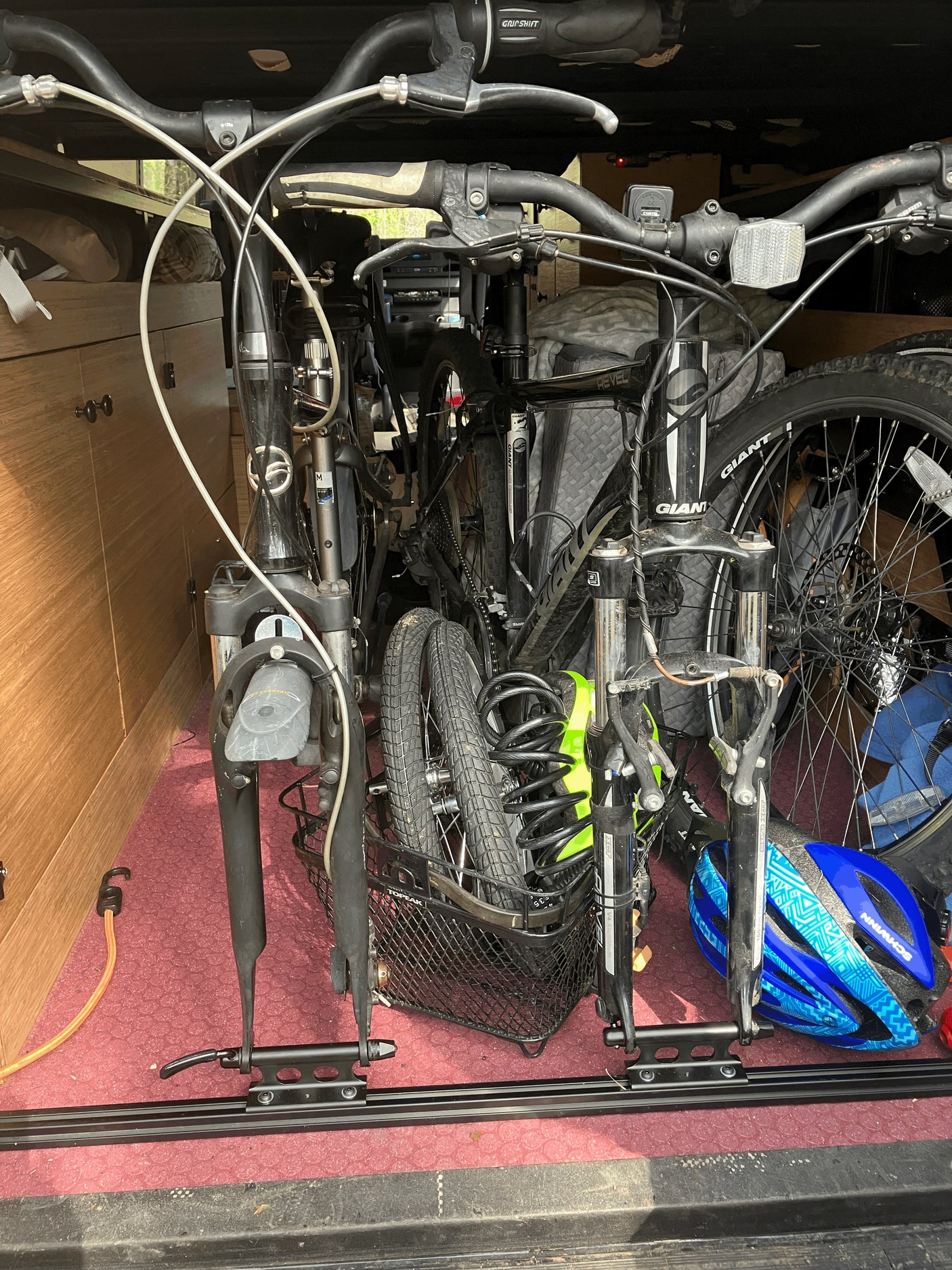 Bicycles stored securely inside an RV rental with a fork-mount system and helmet, ideal for adventure travel.